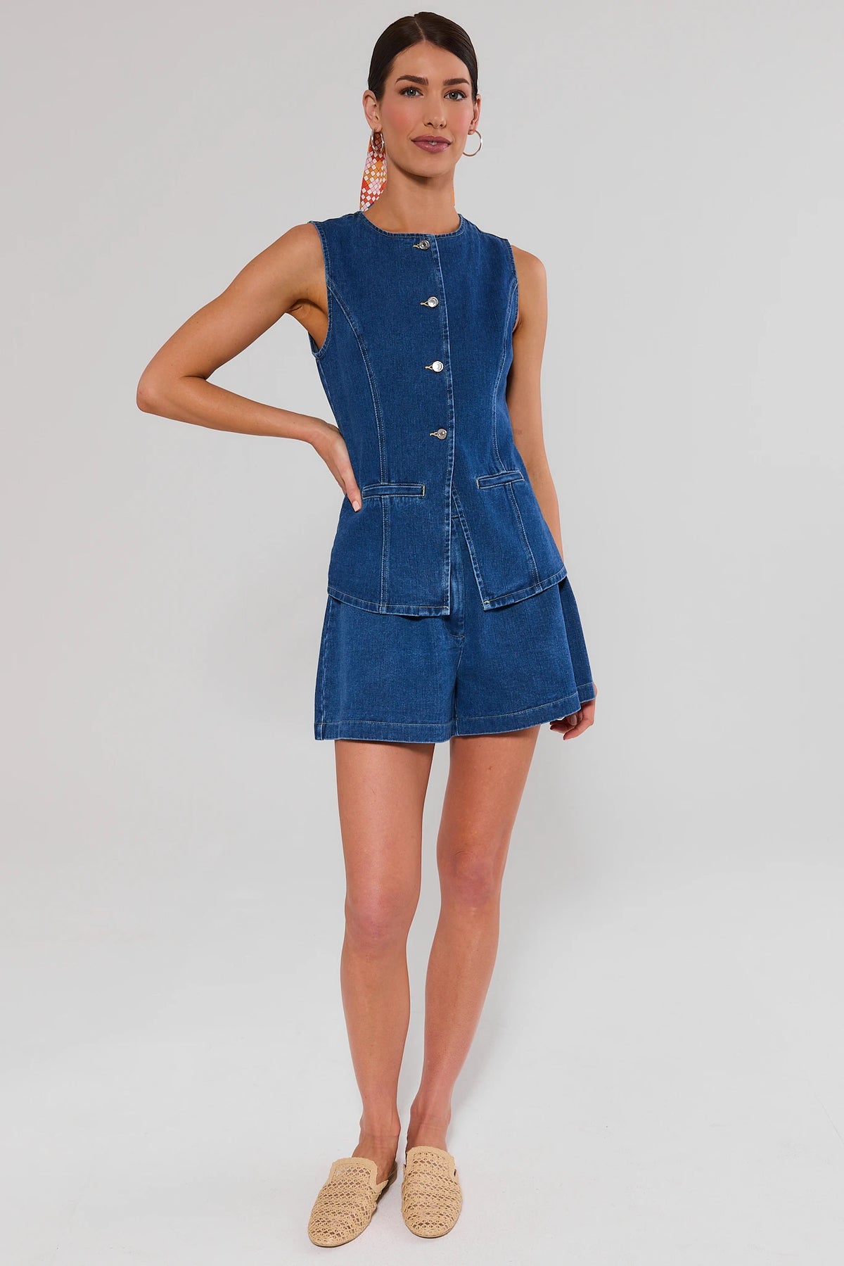 Woman wearing a blue denim top and shorts on a white background