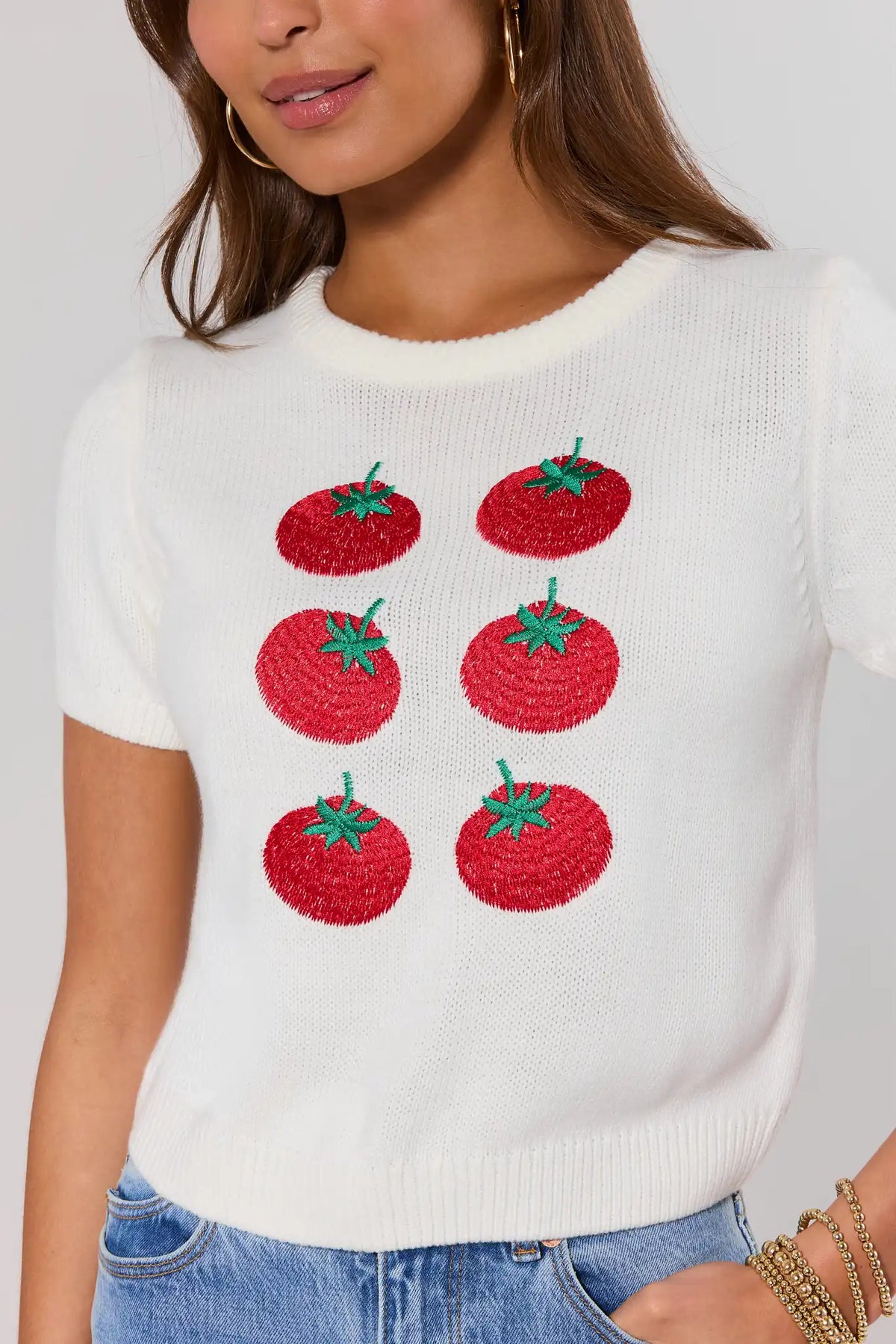 Close-up of white tomato print knit top showing embroidered red tomato detail and crew neckline | Avara