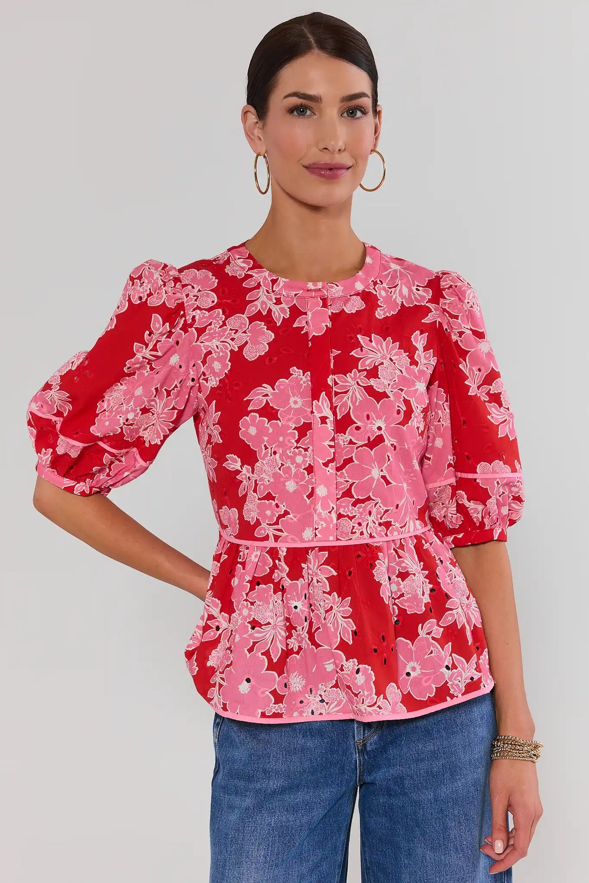 Woman wearing red floral eyelet peplum top with puff sleeves, front view on model | Avara