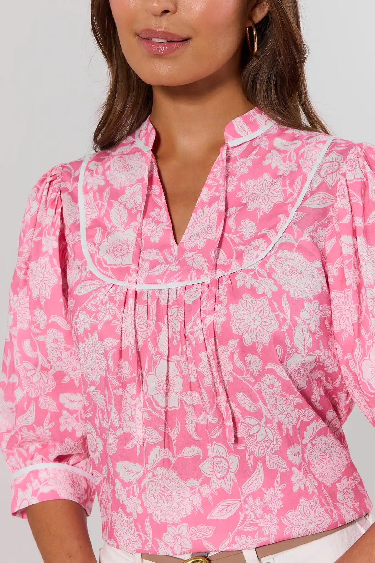 Parker Pink Floral Print Top close-up showing V-neckline, white contrast piping, and pleated bib detail | Avara