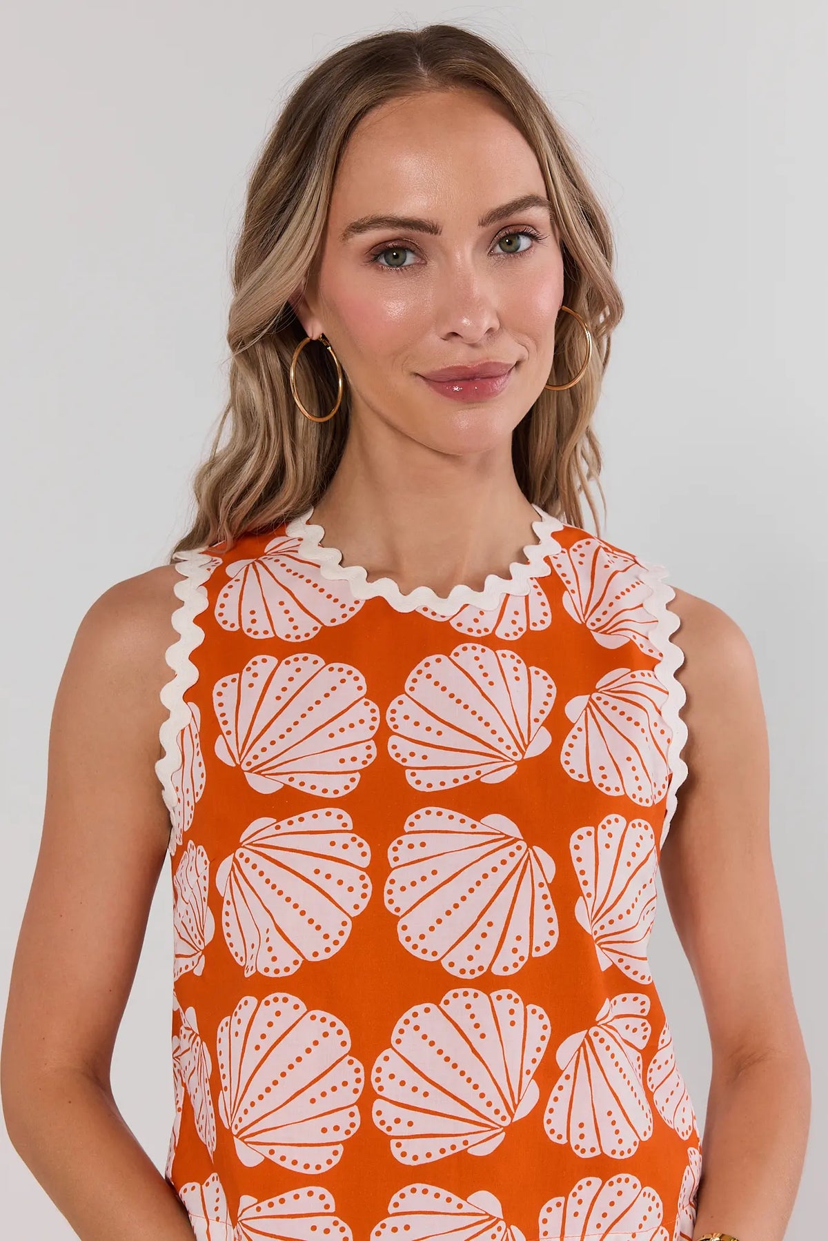 Orange shell print tank top close-up detail showing high neckline with white ric-rac trim | Avara