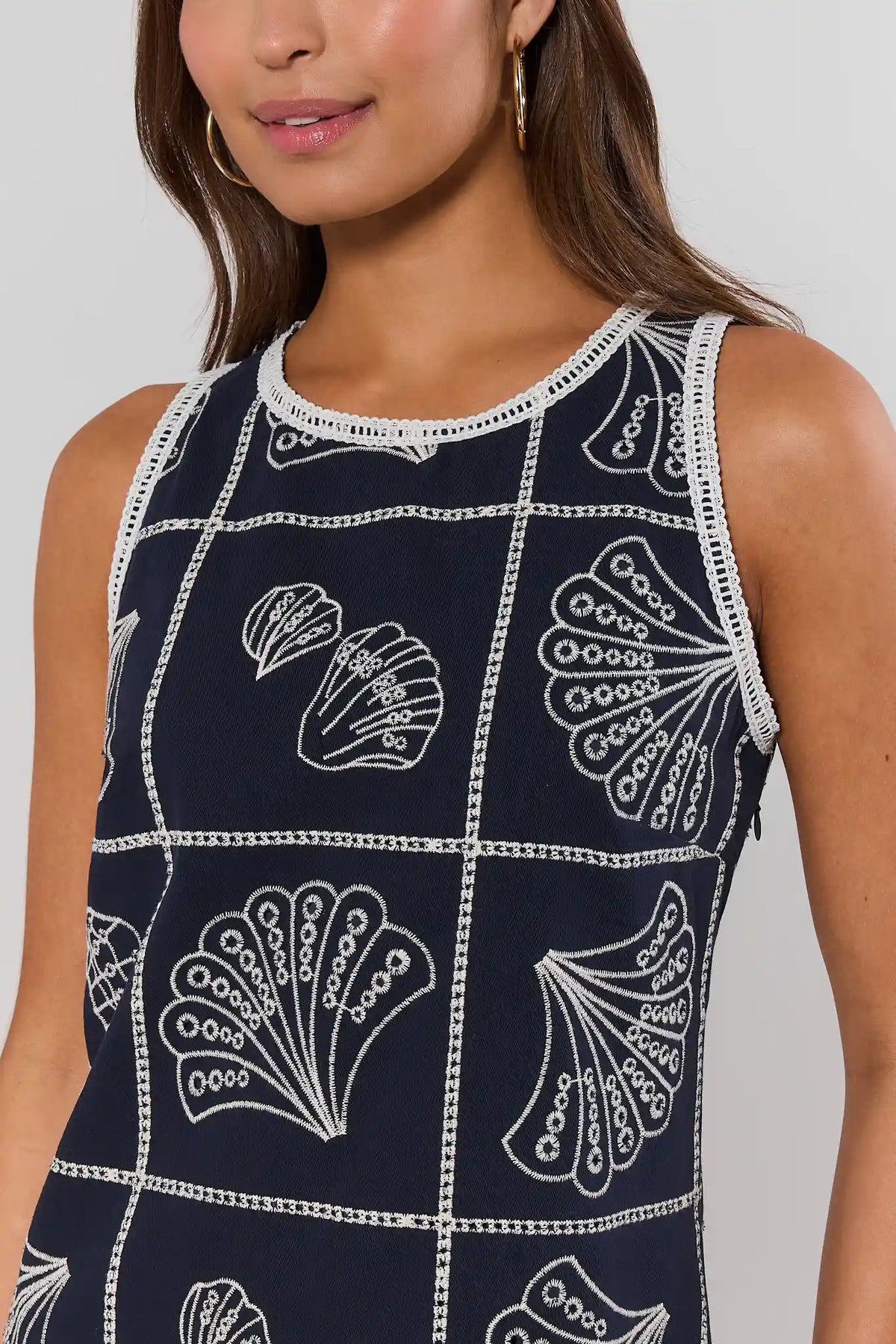 close up Navy dress with white shell pattern worn by a model against a neutral background