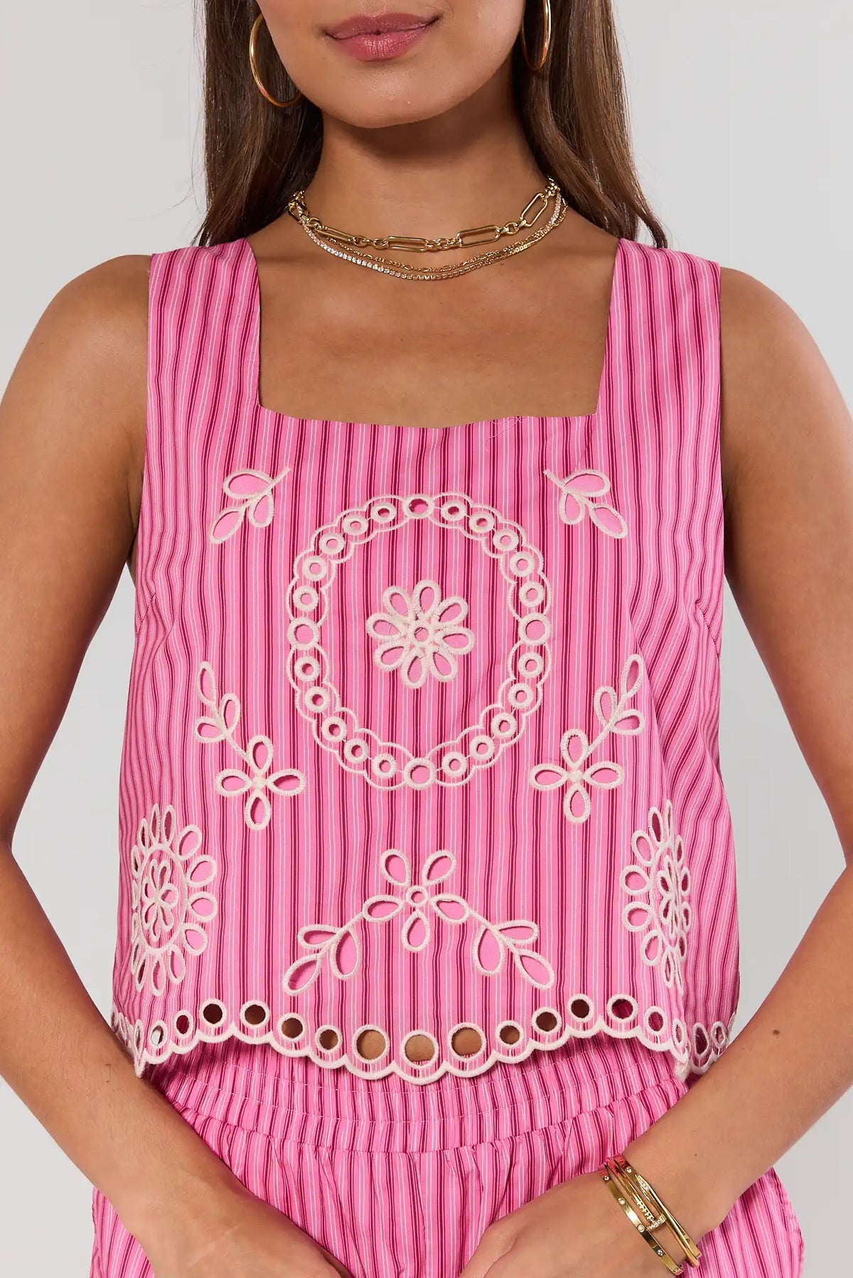 Close-up of pink striped eyelet tank top showing floral embroidery and scalloped hem detail | Avara
