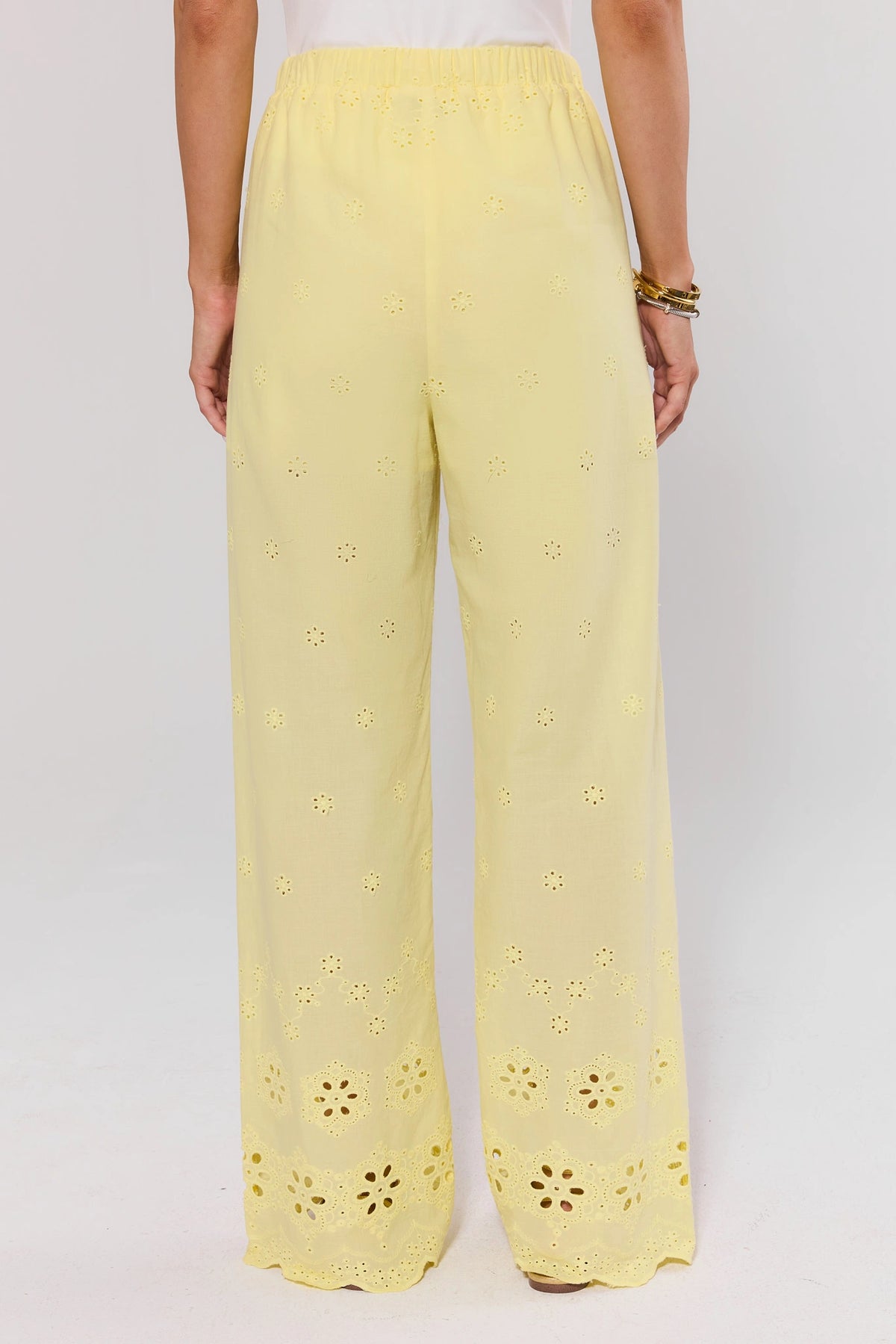 Yellow Eyelet Wide Leg Pants with elastic waist and floral cut-out hem border - Back View On-Model | Avara