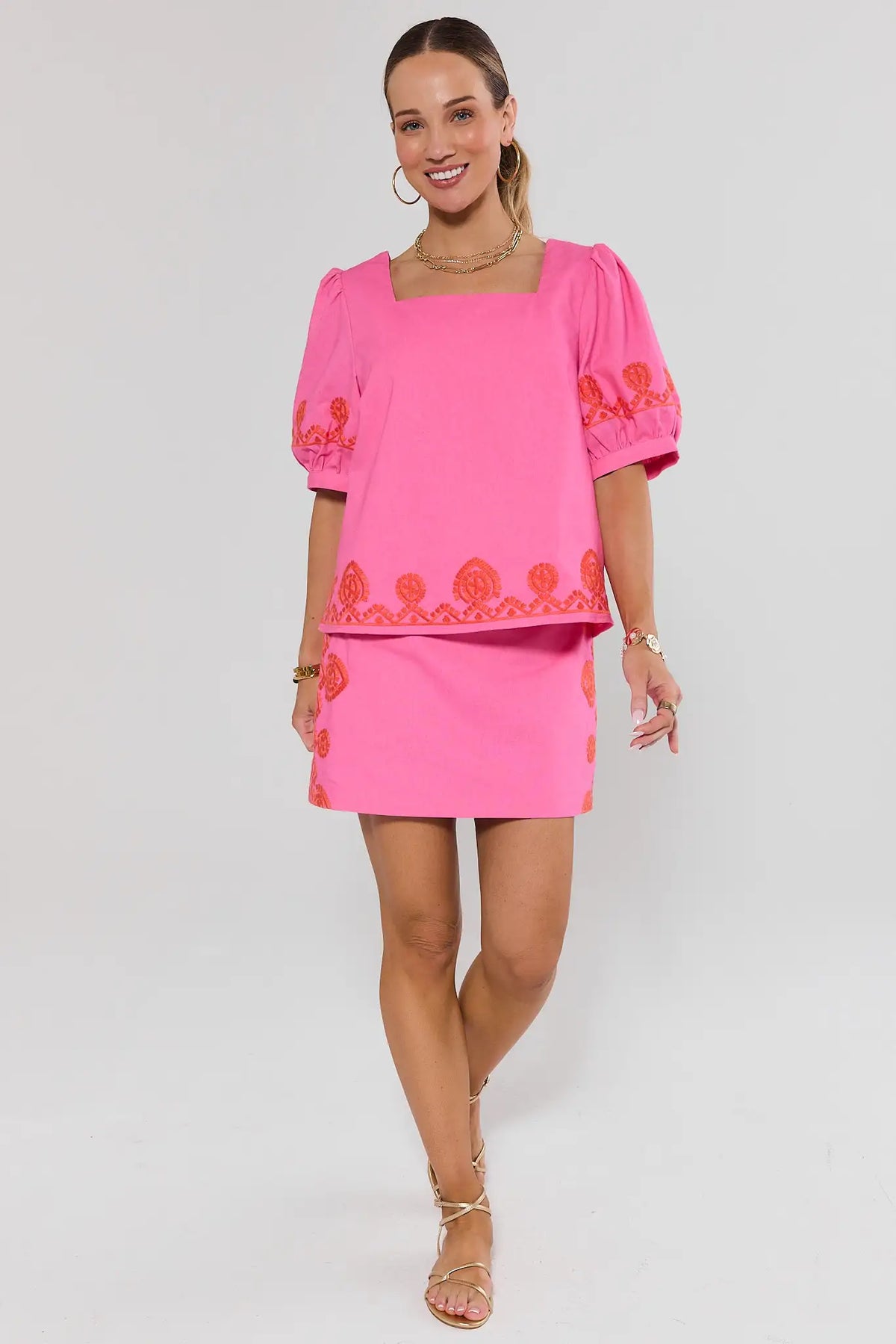 Pink Embroidered Skirt with orange side trim detail - Side View On Model with gold sandals | Avara