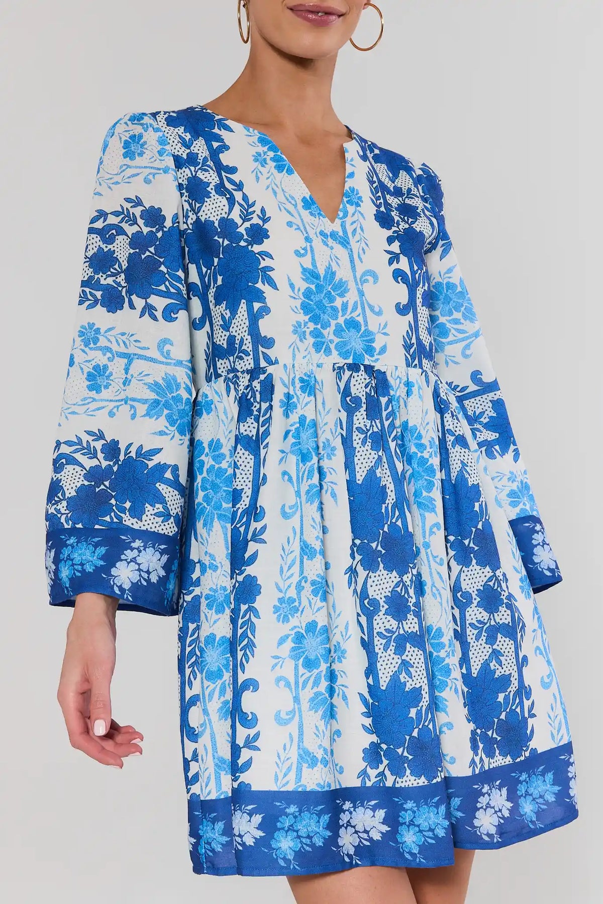 Close-up of blue floral short dress showing smocked waist and bell sleeve detail | Avara