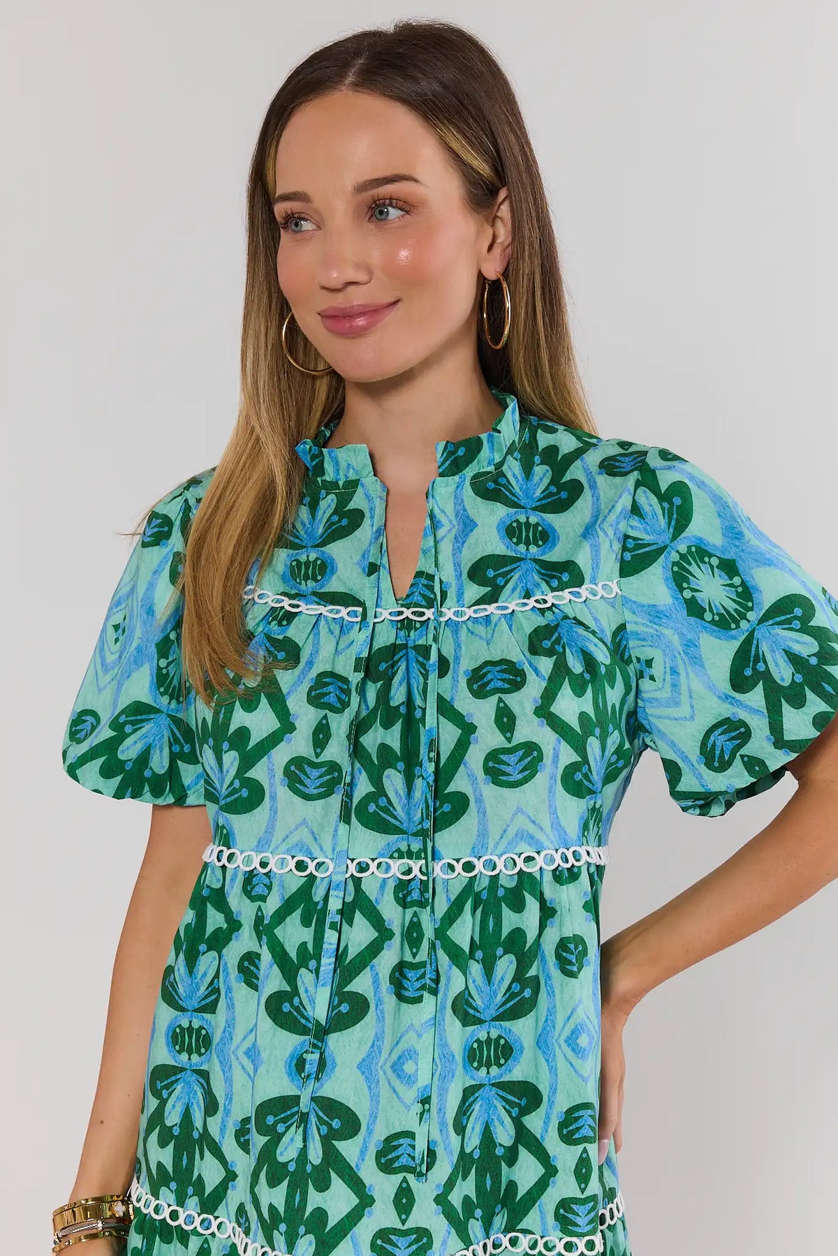 Reina Green Printed Short Dress close-up detail, split neckline and white trim on abstract print | Avara