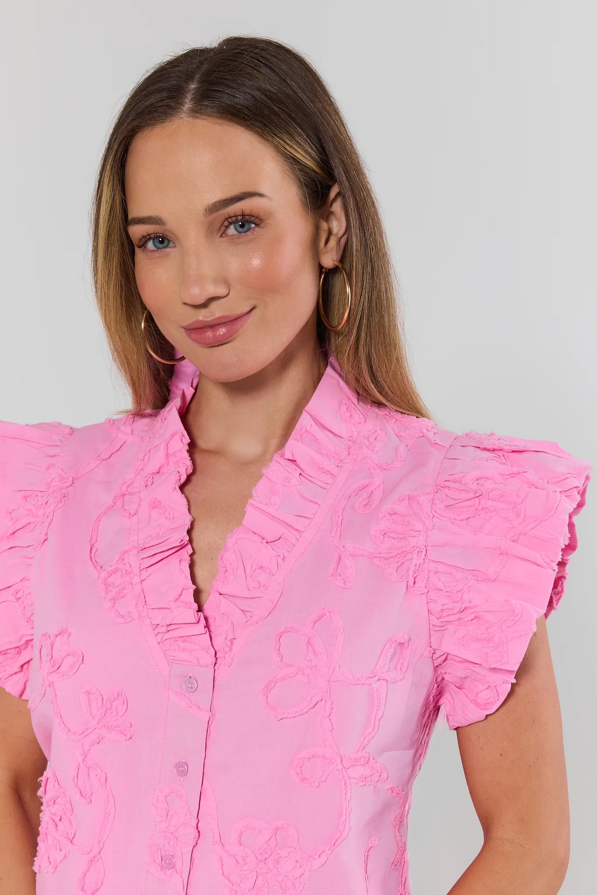 Sandra Light Pink Textured Top close-up showing floral appliqué detail and ruffled neckline | Avara