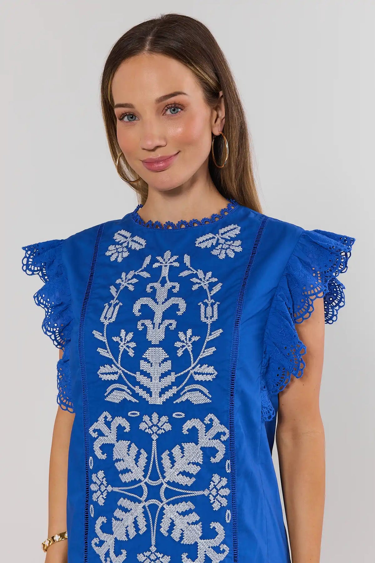 Blue flutter sleeve dress with white floral needlepoint embroidery and lace eyelet sleeves - Close-Up Detail | Avara