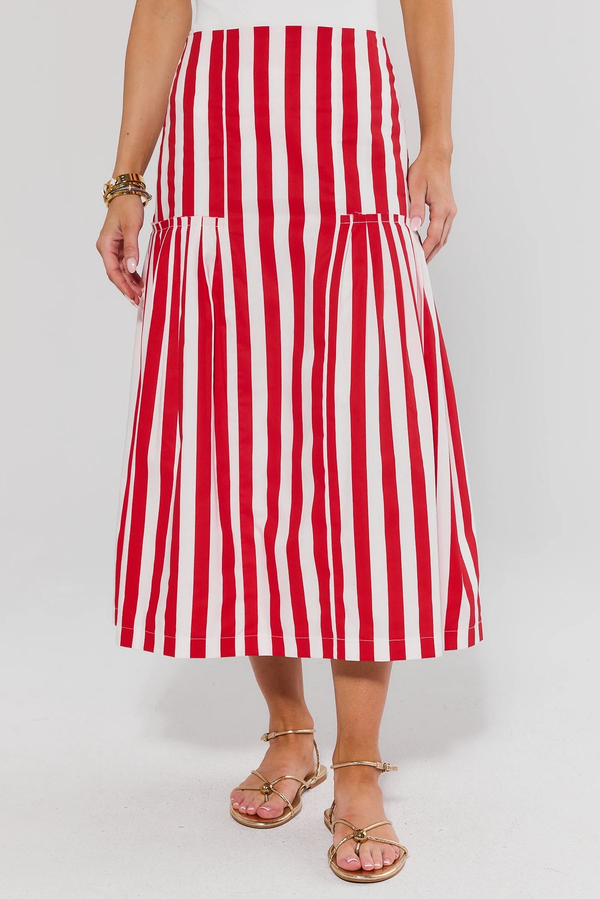 Red and white striped gathered midi skirt - Front View, flowy A-line silhouette with gold sandals | Avara