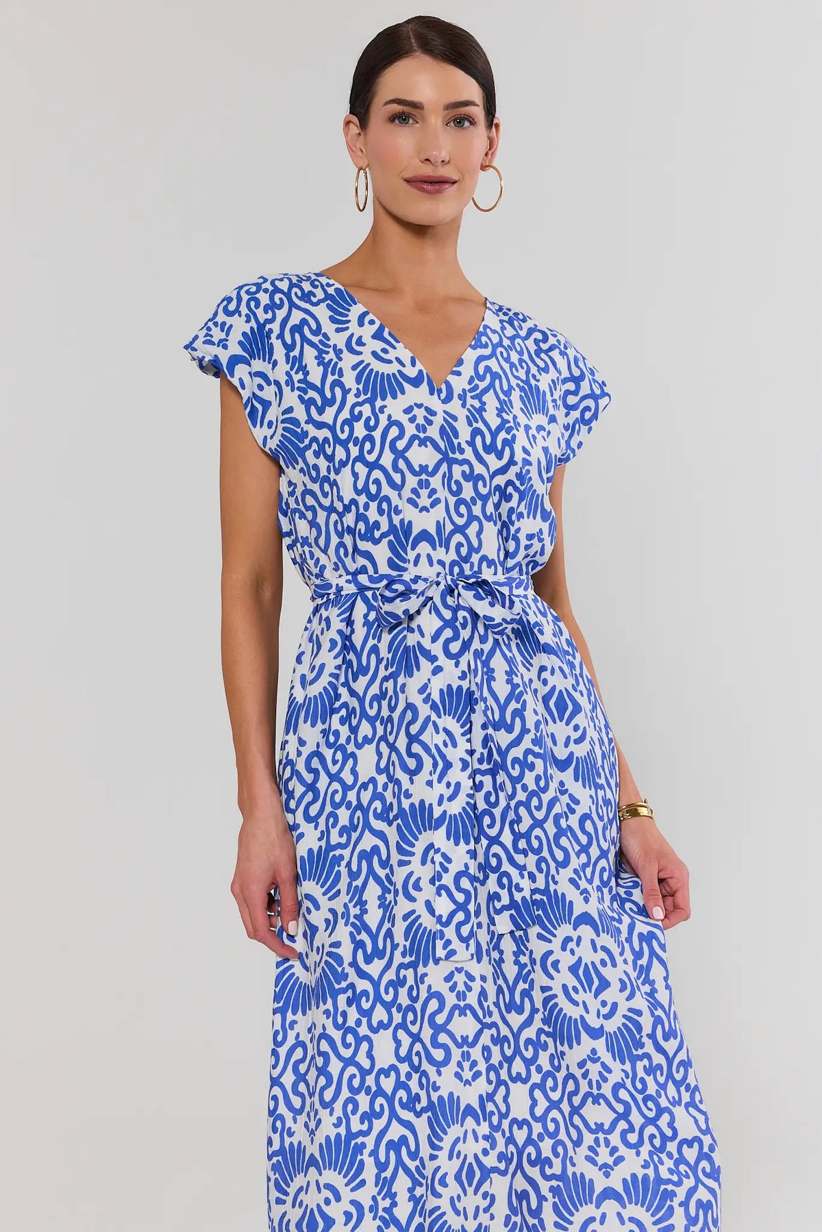 Woman wearing blue printed tie waist midi dress, V-neckline close-up, abstract pattern - Front Detail | Avara