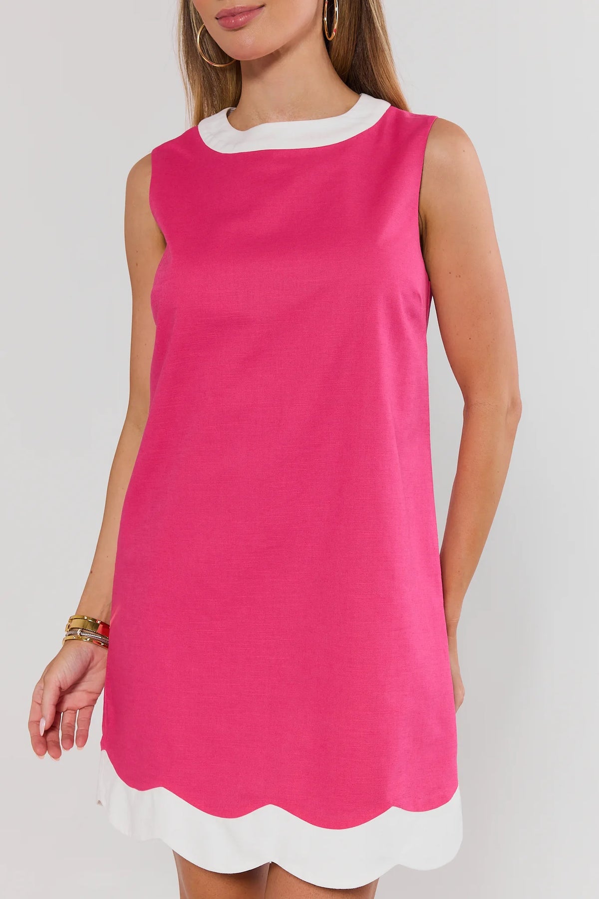 Close-up of pink dress with white scalloped contrast hem and crew neckline detail - Front Detail | Avara