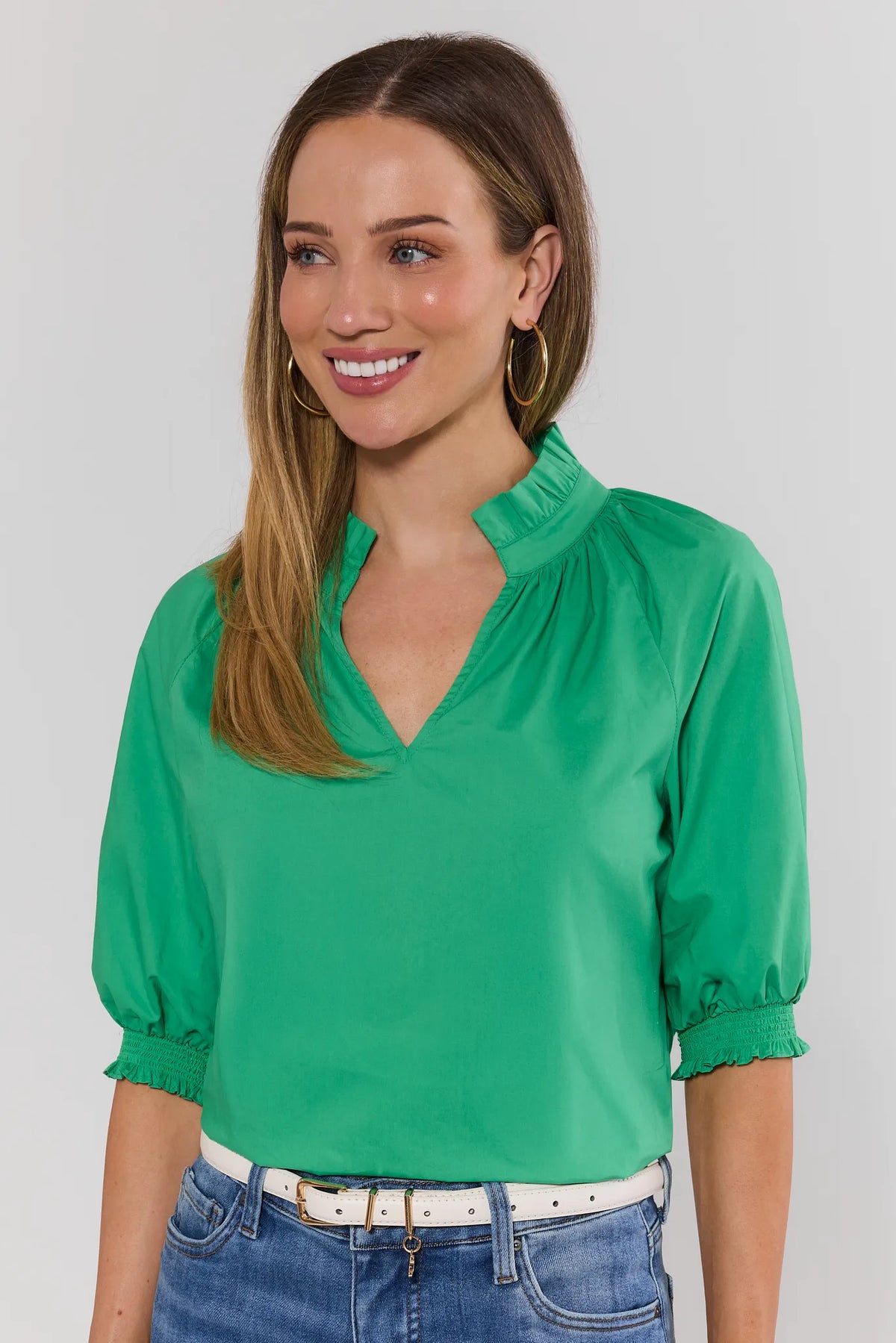 Merrick Green Split Neck Top with smocked cuffs and ruffle collar, front view on model with denim | Avara