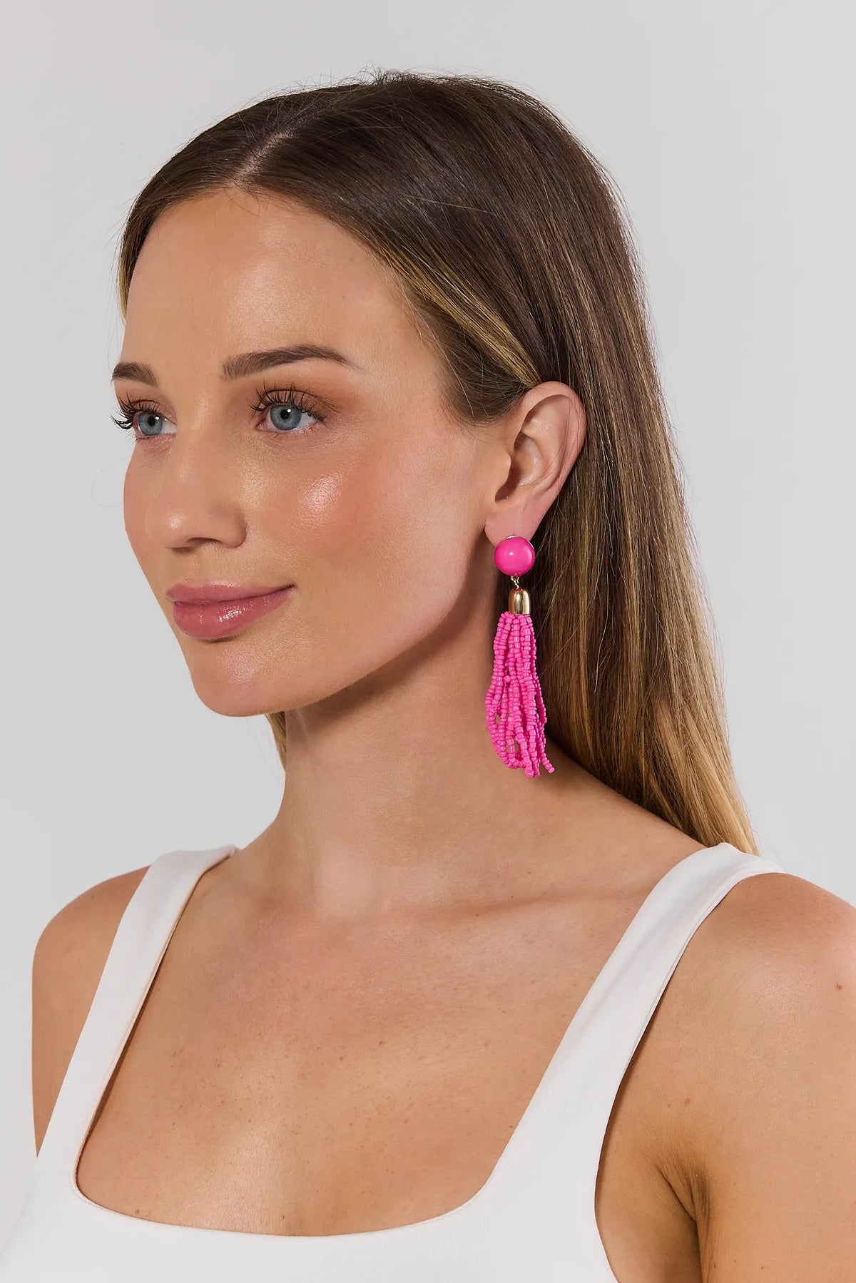 Woman wearing hot pink beaded tassel drop earrings - Side Profile On Model | Avara