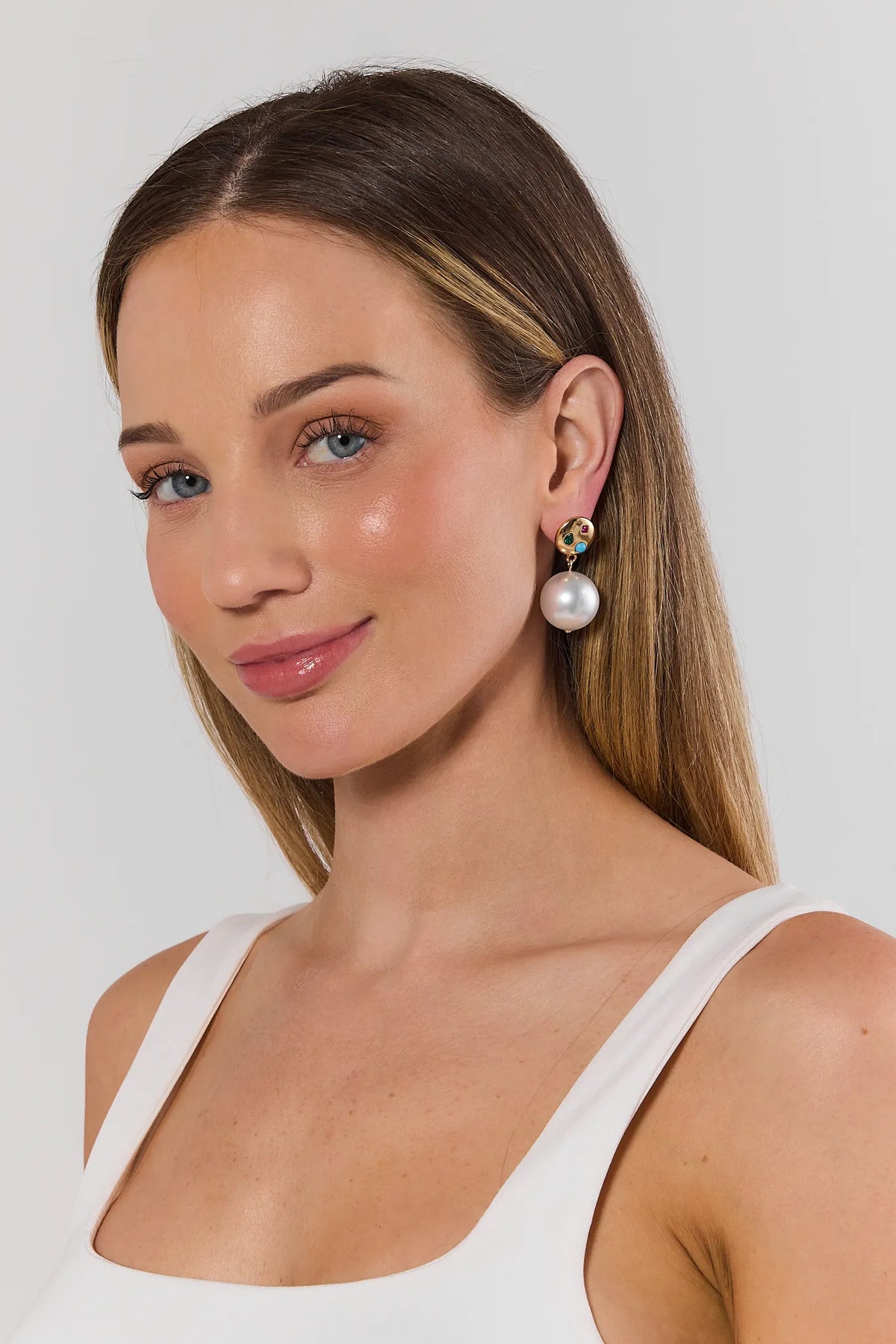 Woman wearing white pearl drop earrings with colorful gemstone gold stud - On Model | Avara