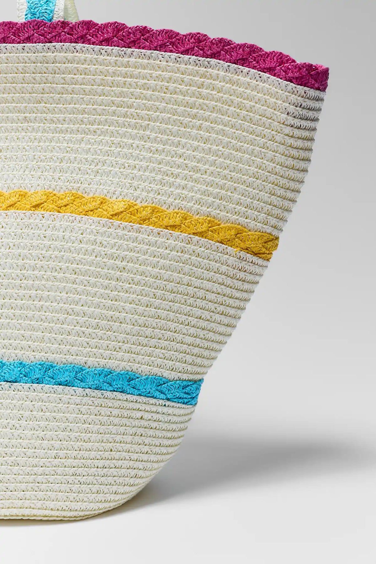 Tan woven straw tote bag with braided teal, yellow, and pink stripe detail - Close-Up | Avara