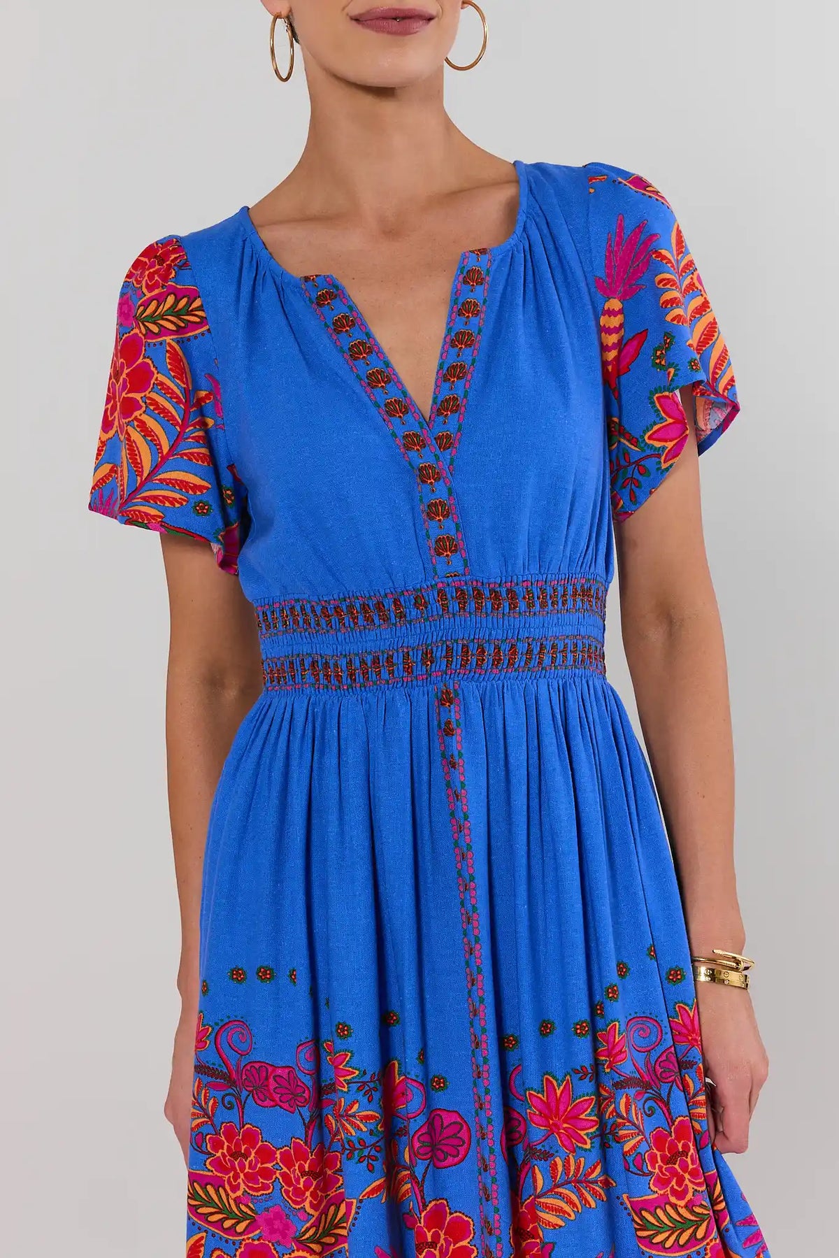 Blue floral maxi dress close-up, V-neckline and smocked waist detail, short flutter sleeves | Avara