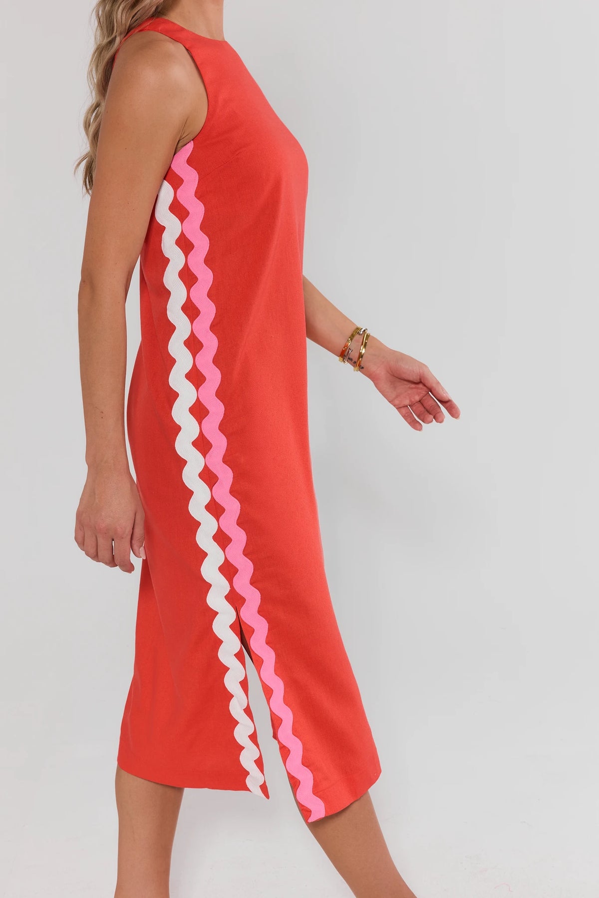Red dress with pink and white striped sides on a plain background walking