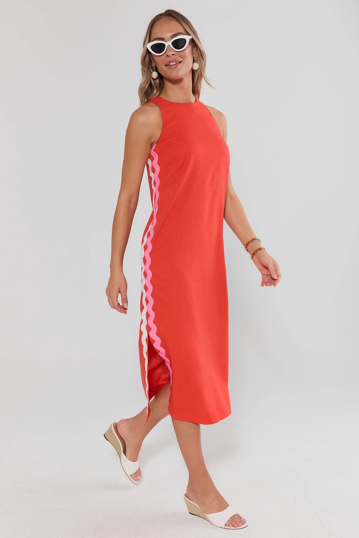 Woman wearing a red dress with a pink side panel on a white background