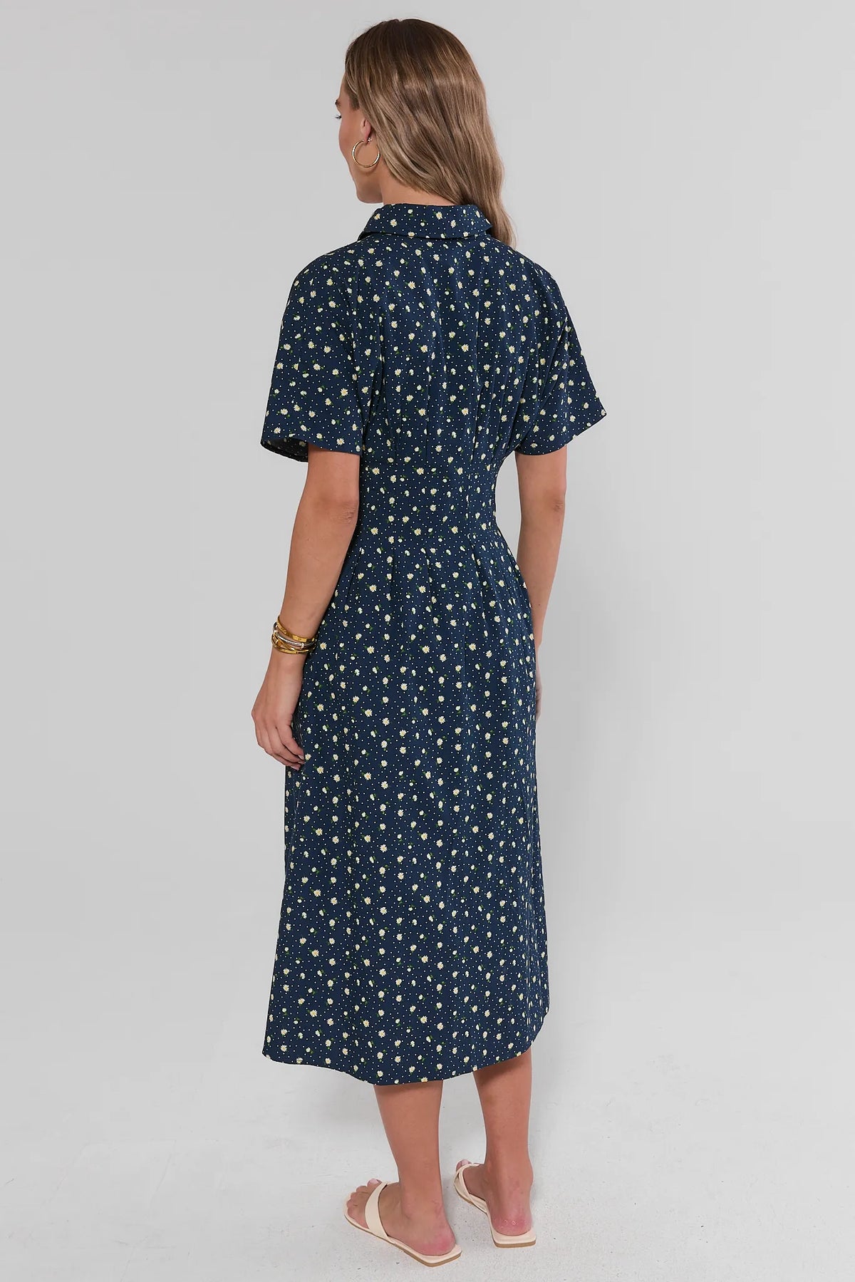 Navy daisy floral button-up maxi dress back view showing midi-length skirt and short sleeves | Avara