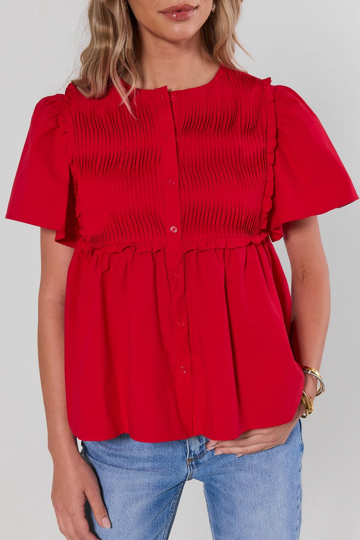 Libby Red Smocked Peplum Top micro-pleat and ruffle detail close-up, flutter sleeves - Front Detail | Avara