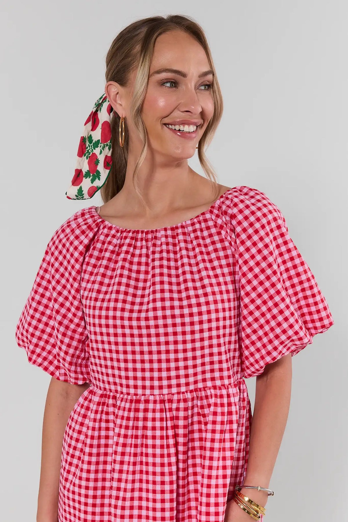 Red gingham boat neck dress close-up showing puff sleeve and gathered waist detail | Avara