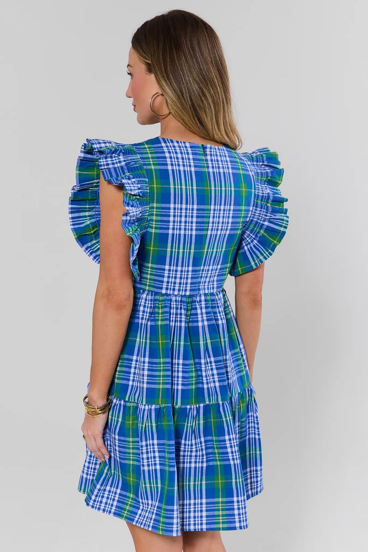 Blue plaid short dress back view with smocked flutter sleeves and tiered A-line skirt on model | Avara