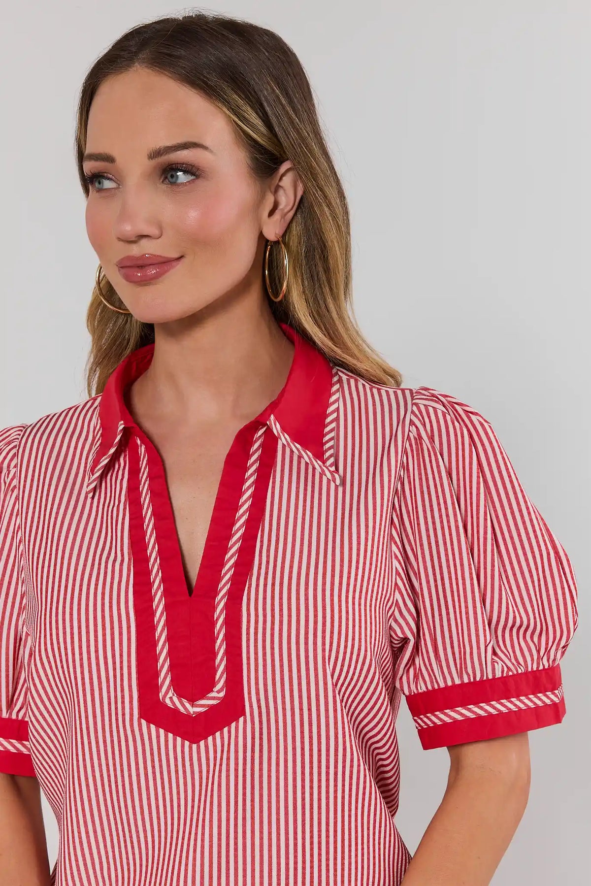 close up Woman wearing a red and white striped shirt with a plain background