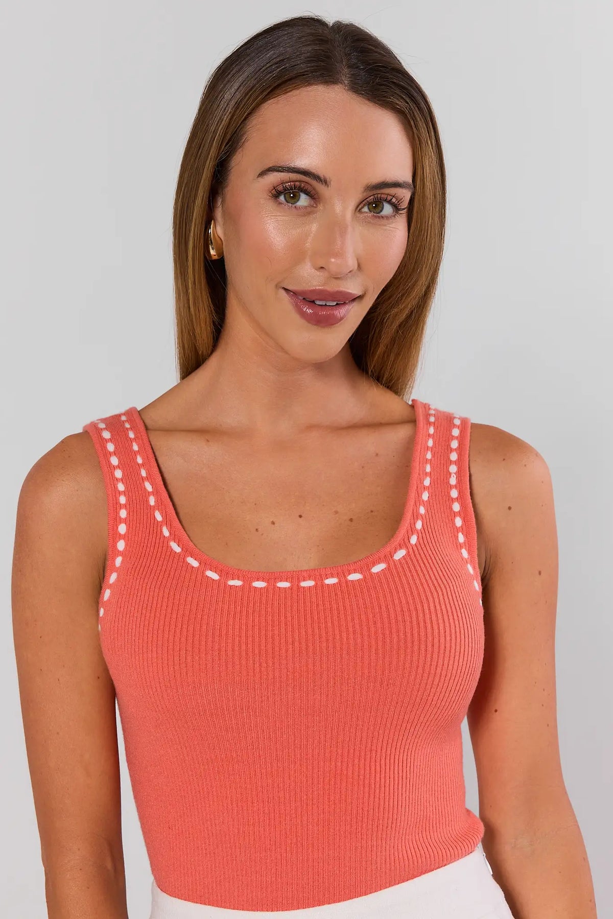 Coral orange ribbed tank top with white contrast stitching and scoop neckline - Close-Up Detail | Avara