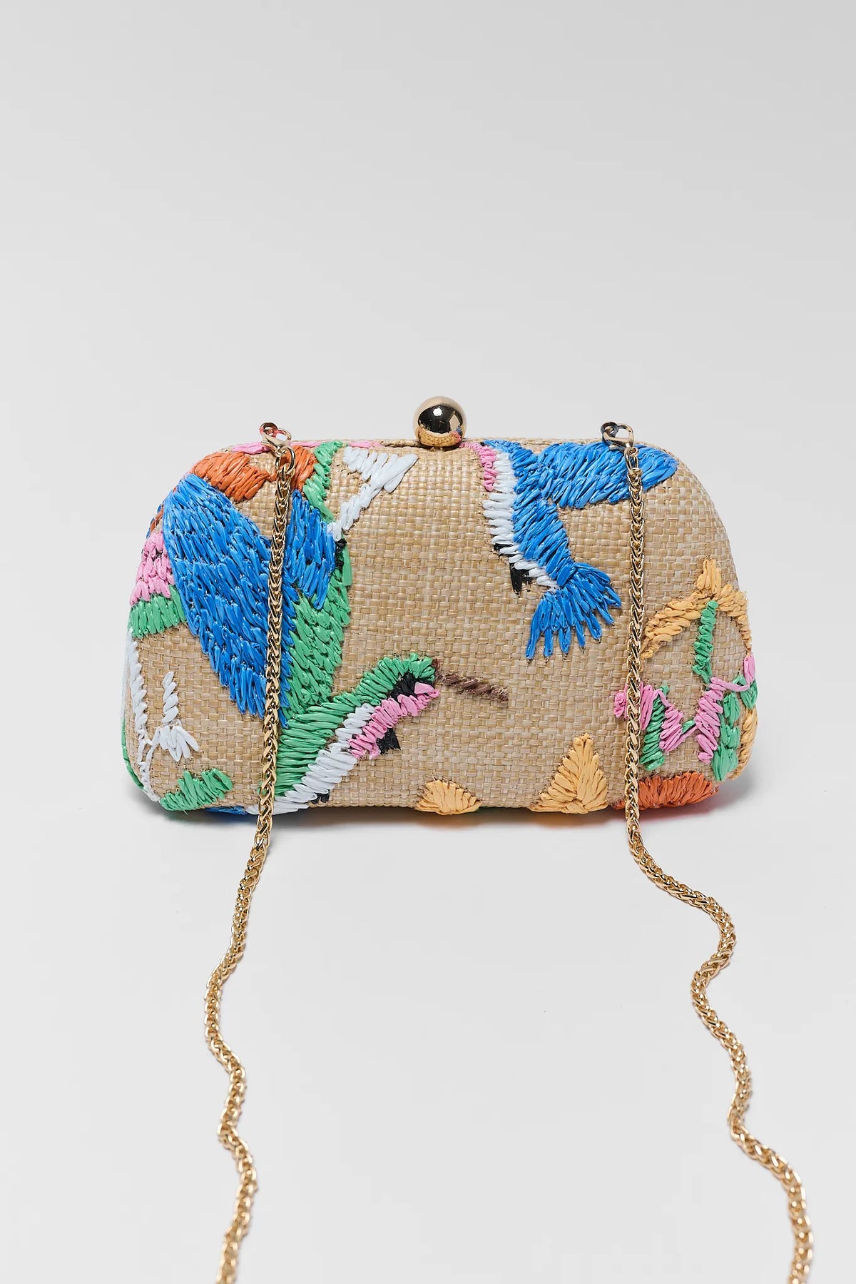 Woven handbag with colorful floral patterns on a light gray background