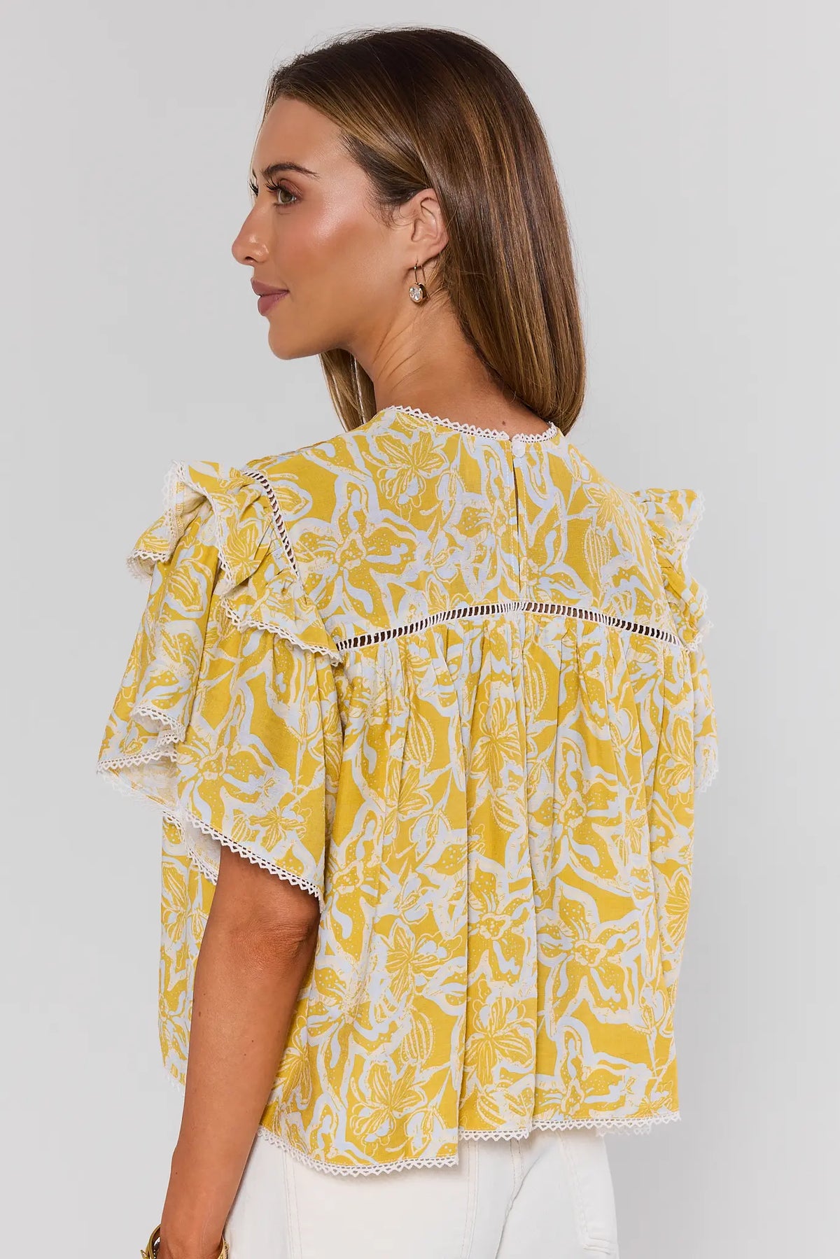 Yellow printed flutter sleeve top back view showing pleated detail and lace-trim ruffle sleeves | Avara
