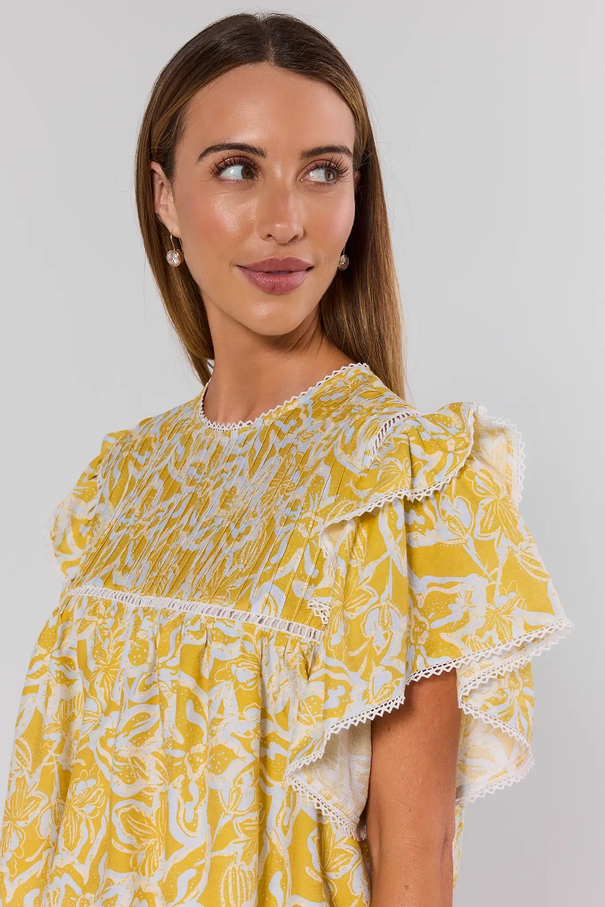 Yellow printed flutter sleeve top close-up detail showing lace trim and ruffle sleeves | Avara