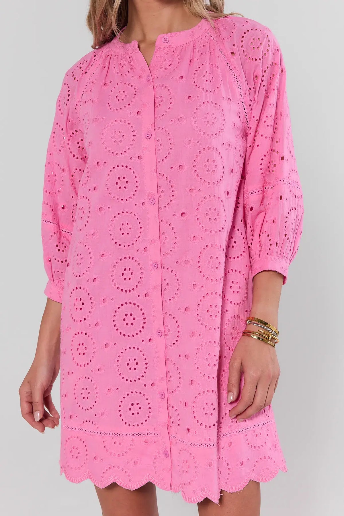 Pink eyelet short dress close-up showing scalloped hem and circle embroidery detail | Avara