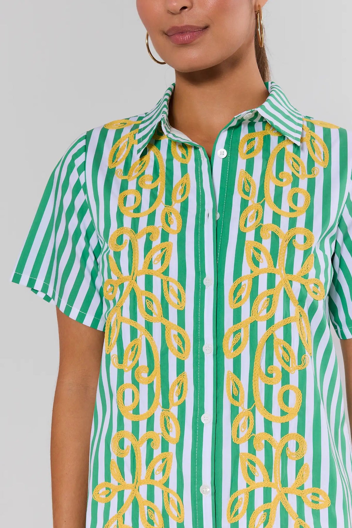 Green striped short dress with yellow contrast embroidery detail, close-up of collar and button front | Avara