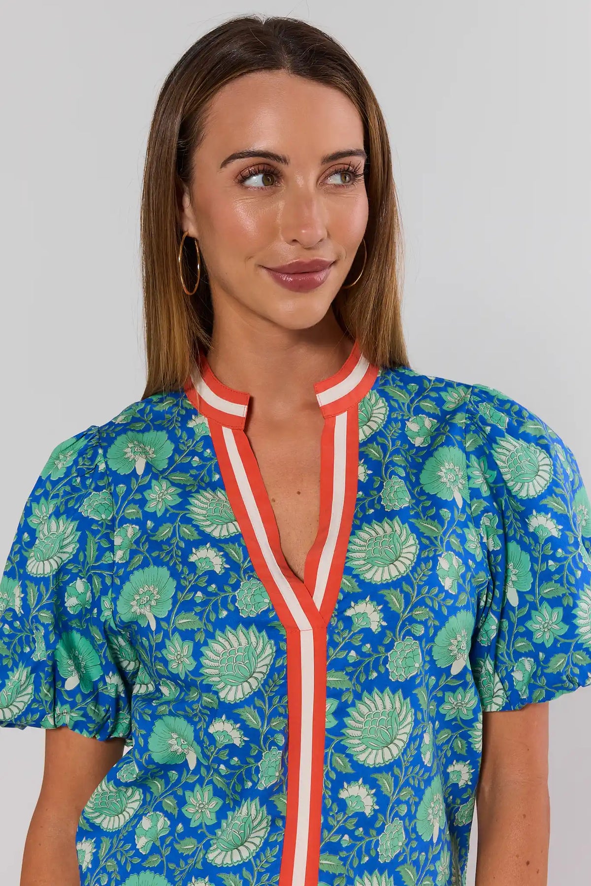 Blue floral top close-up showing coral contrast V-neckline trim detail - THML | Avara