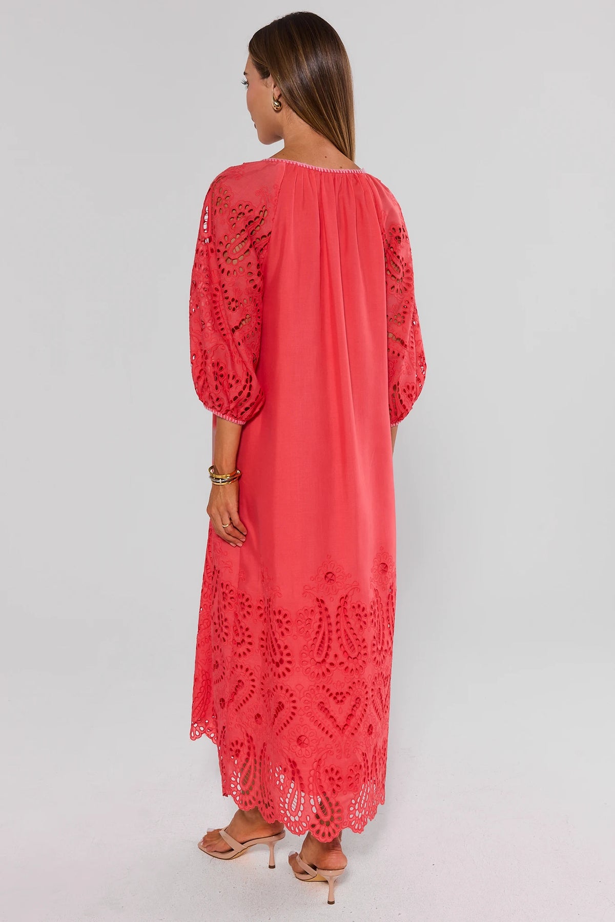 Back view of coral eyelet midi dress showing gathered neckline, puff sleeves, and scalloped eyelet hem | Avara