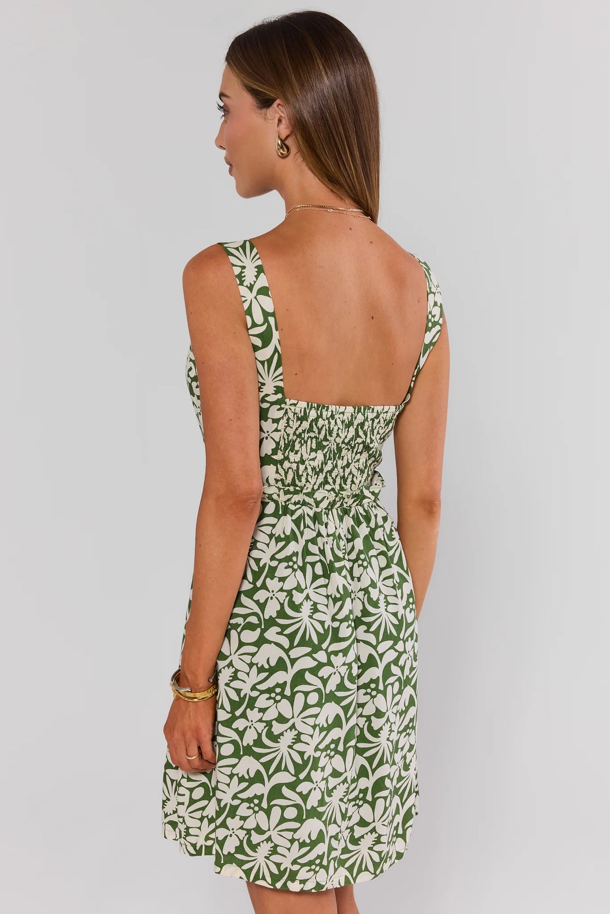 Green and cream floral print short dress back view showing smocked waist | Avara