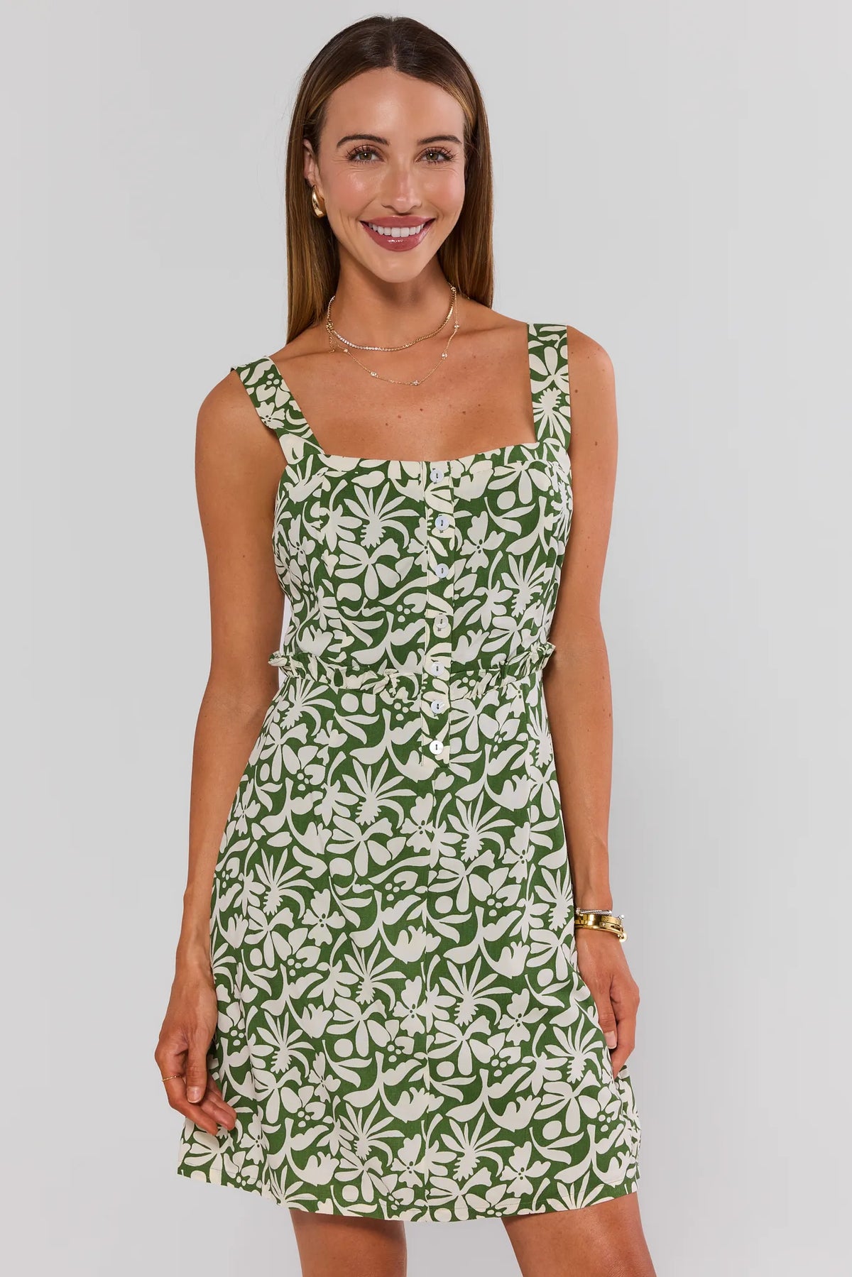 Green floral printed short A-line dress front view styled with gold sandals | Avara