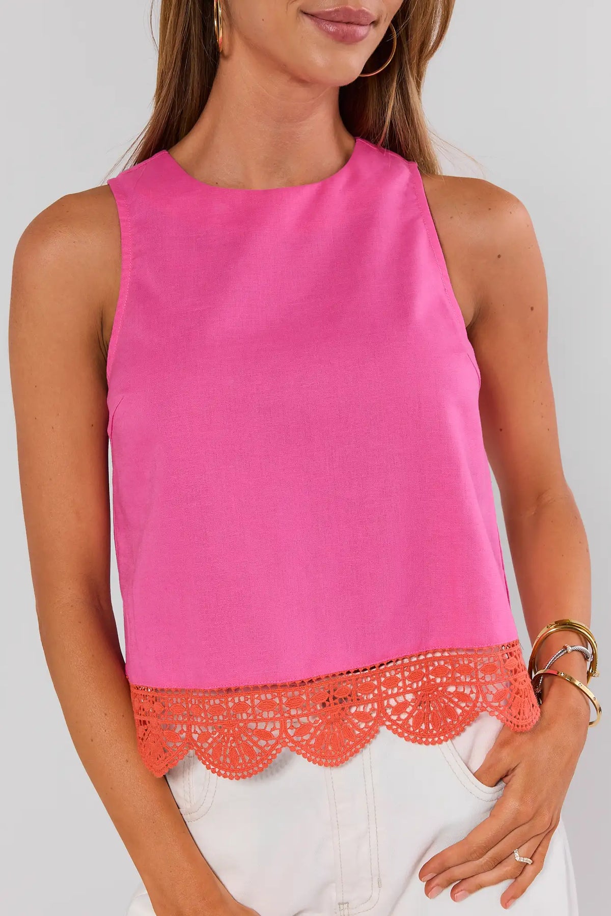 Pink eyelet trim tank top close-up detail showing orange crochet scalloped hem, on model | Avara