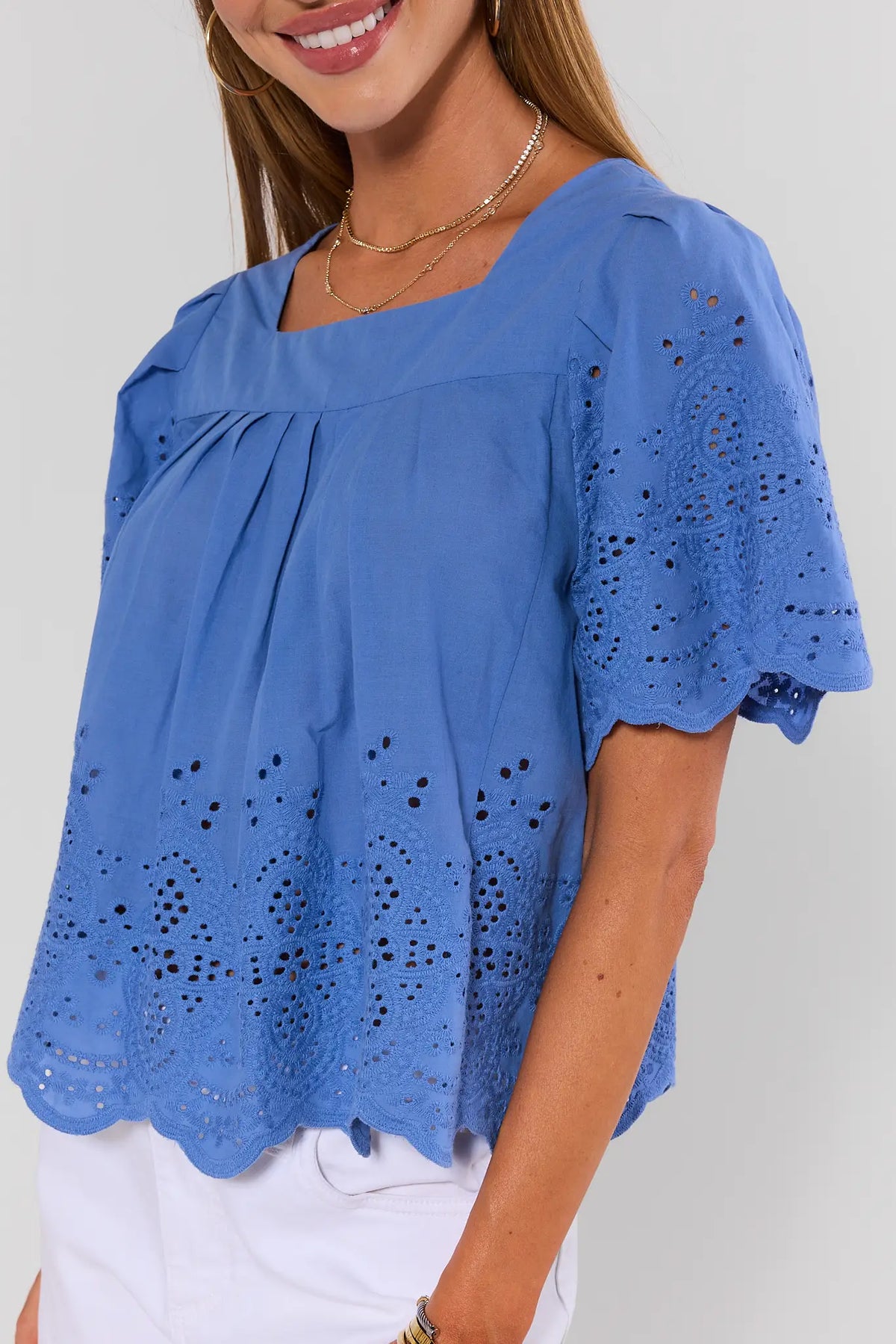 Blue eyelet blouse square neckline and floral embroidered sleeves close-up detail - Side View | Avara