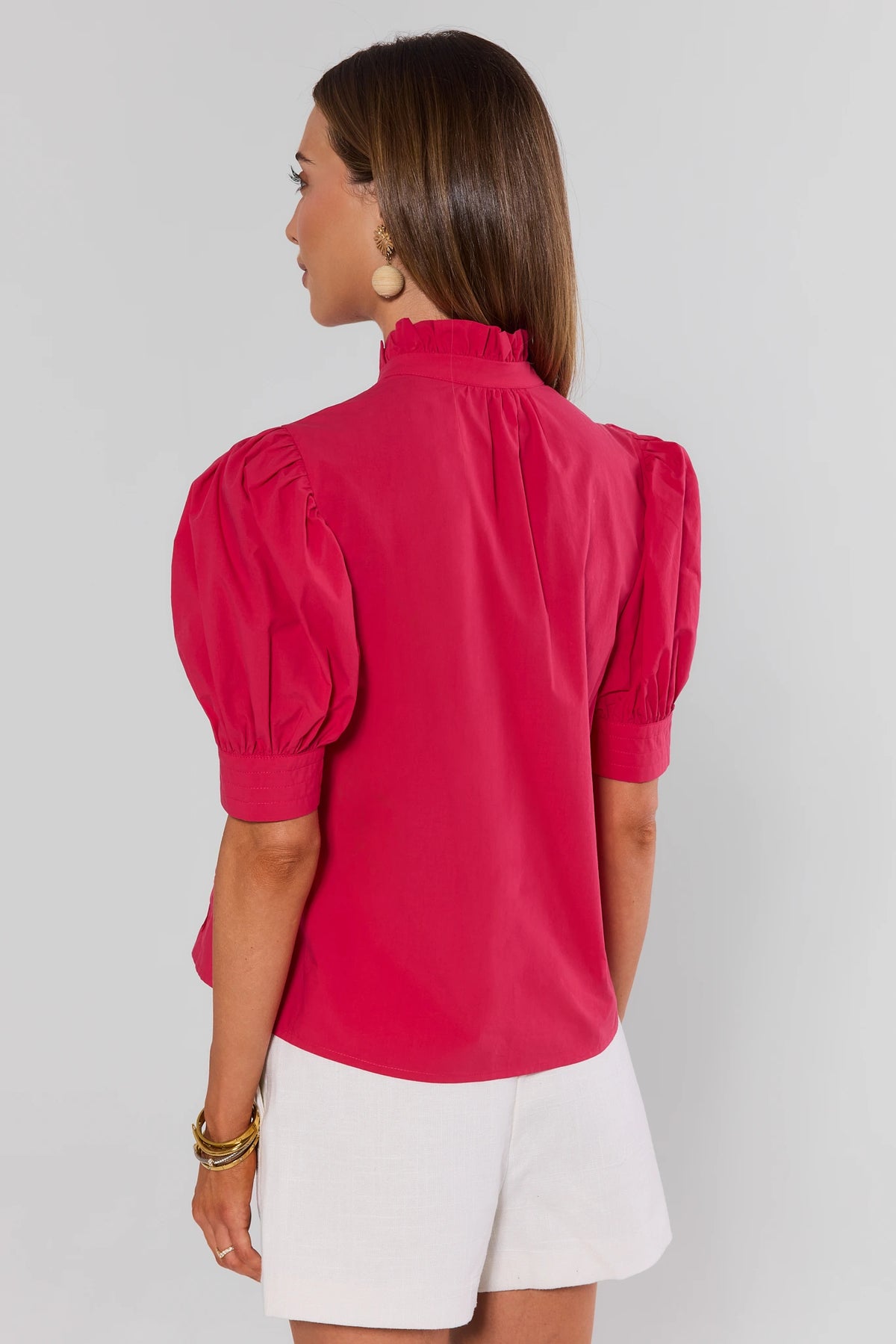 Back view of hot pink button-up top with puff sleeves and ruffle mock neckline, paired with white shorts | Avara