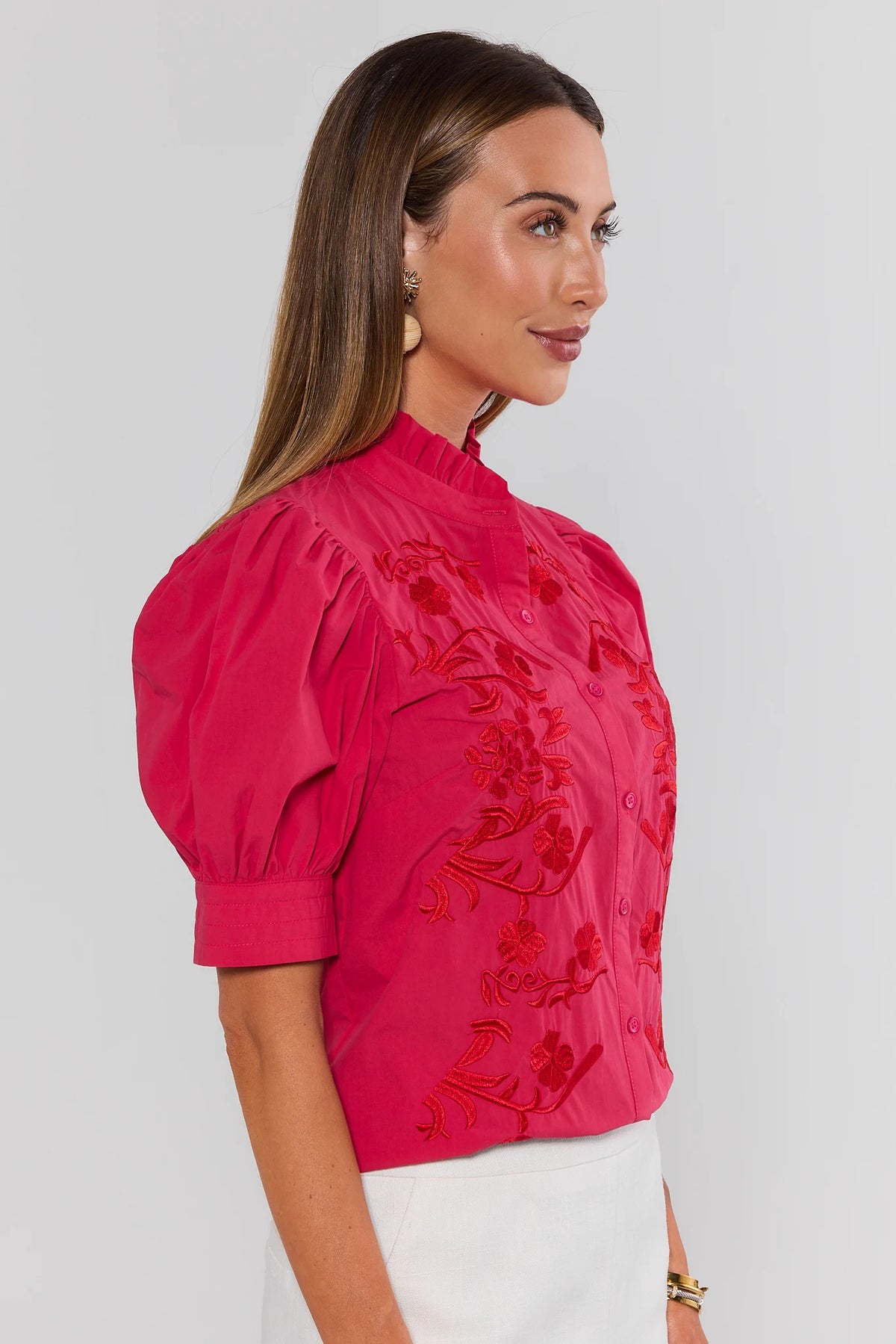 Hot pink embroidered button-up top showing red floral detail and puff sleeve cuff - Side Profile View | Avara