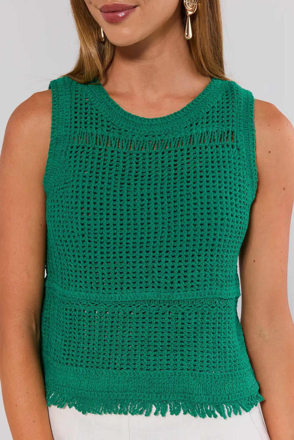 Green knit tank top close-up showing crochet texture, crew neckline, and fringe hem detail | Avara