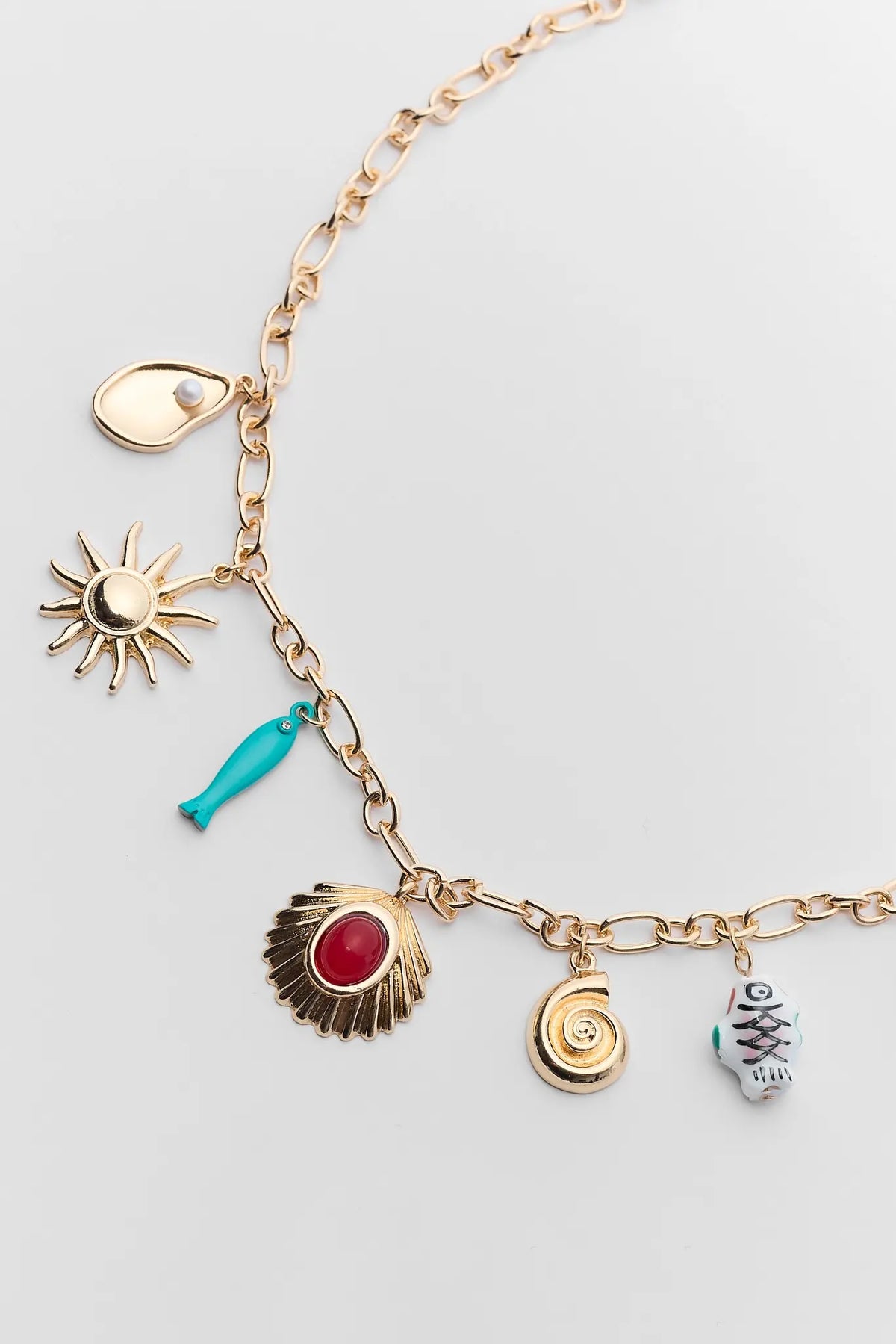 Gold chain charm necklace close-up featuring seashell, sun, turquoise fish & snail charms | Avara