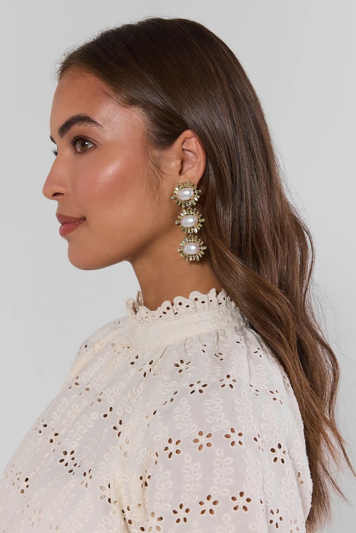 woman wearing beautiful pearl and rhinestone earrings