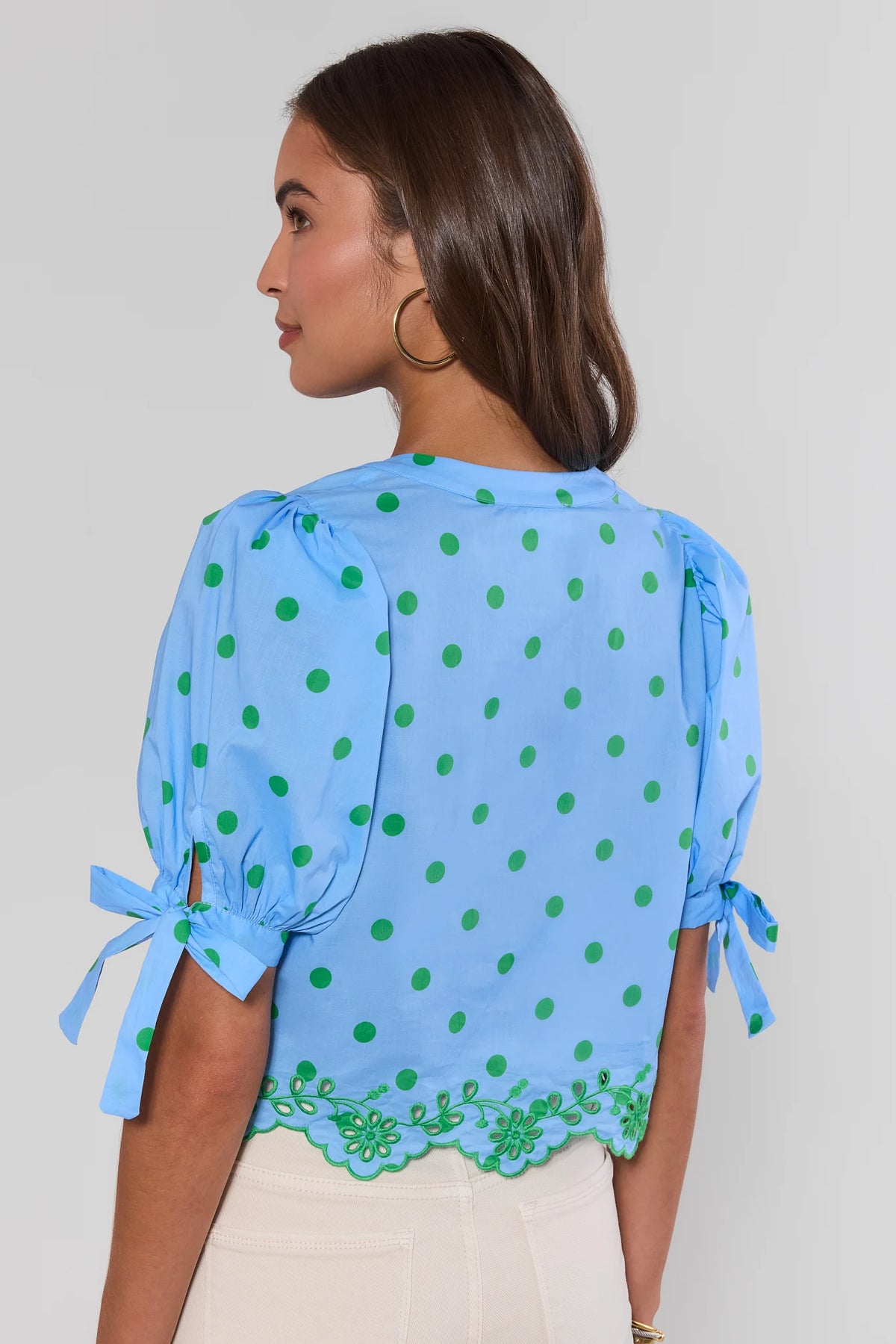 Woman wearing light blue polka dot top with green eyelet scallop hem - Back View | Avara