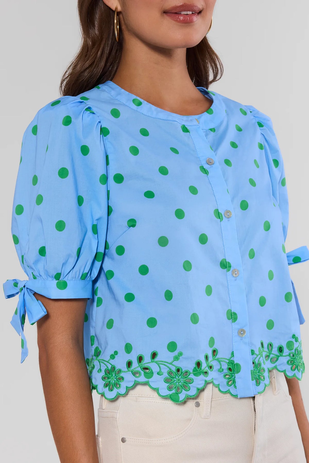 Blue polka dot top with green floral eyelet hem and puff sleeves - Close-Up Detail | Avara