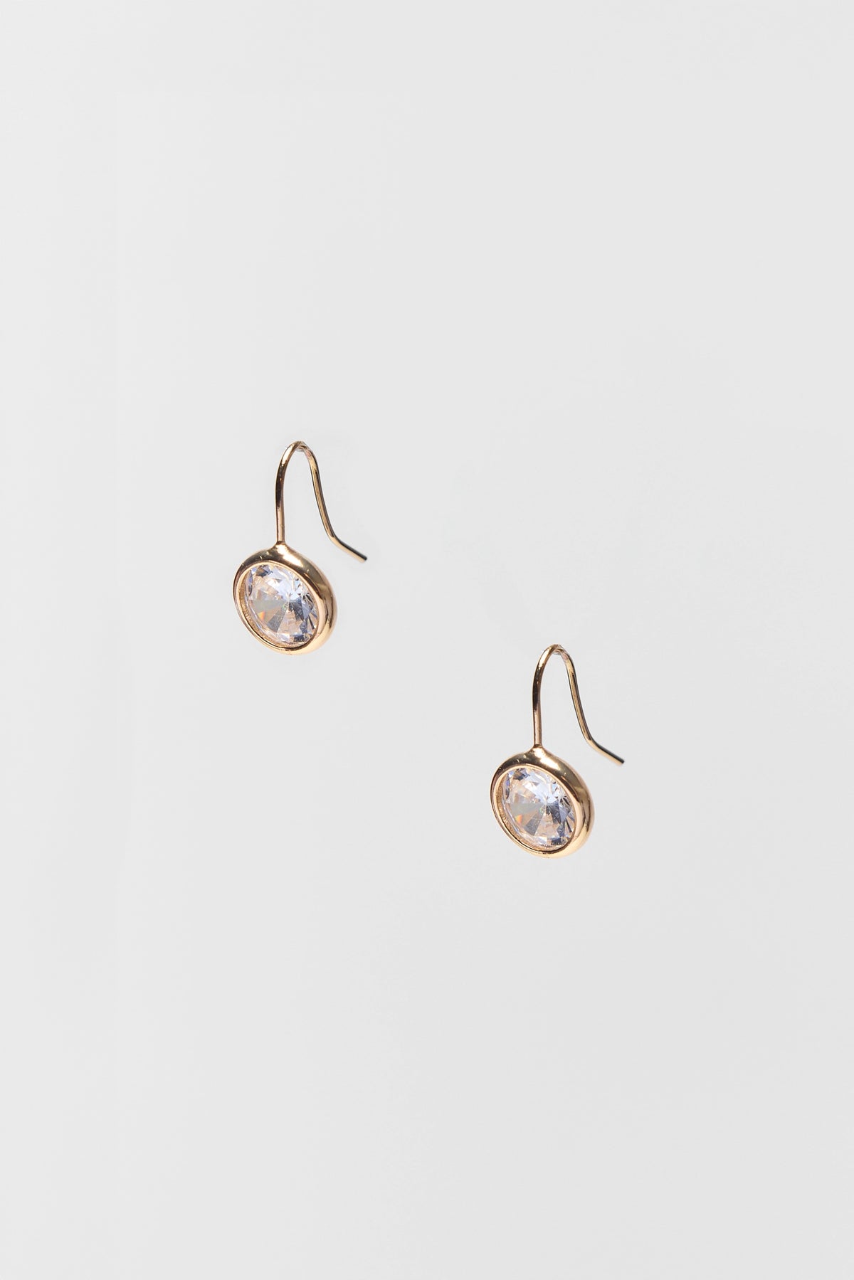 Gold Rhinestone Drop Earrings with oval clear crystal bezel setting - Flat Lay | Avara