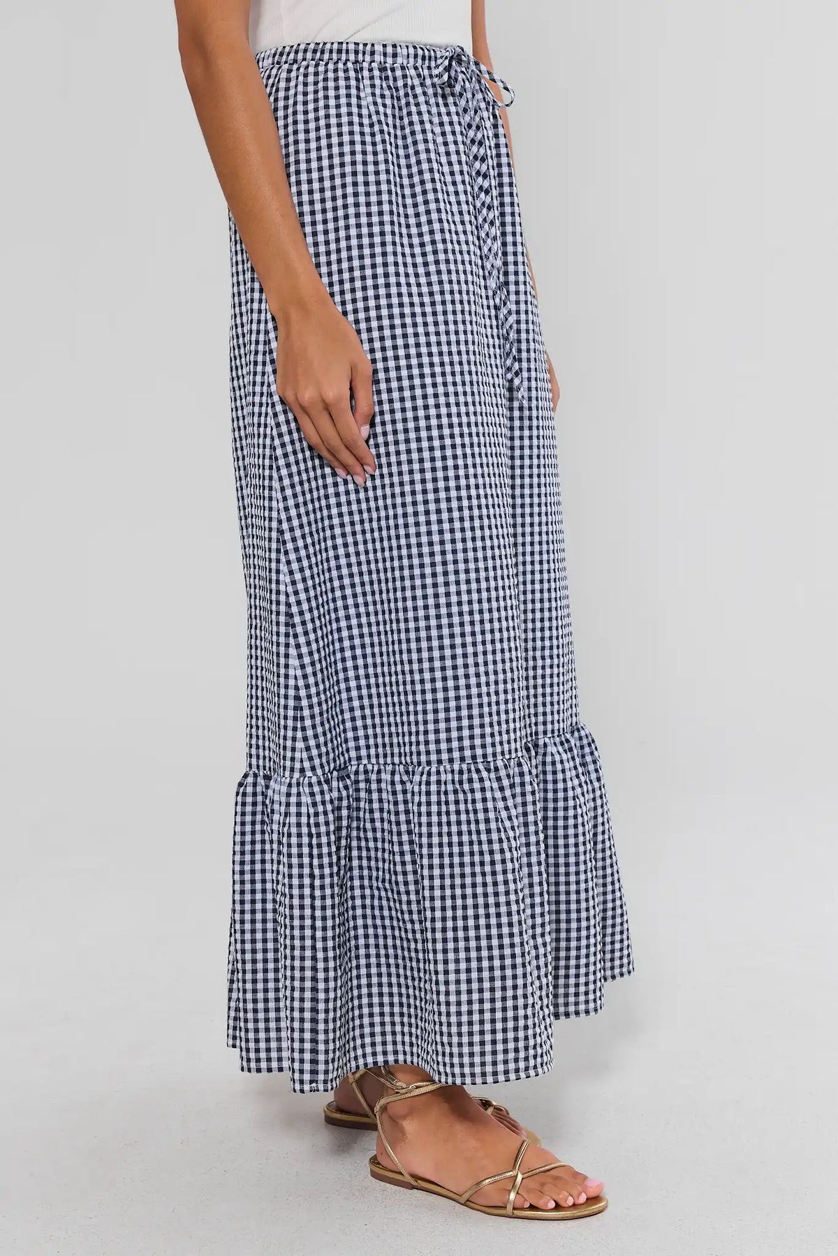 Navy blue gingham ruffle maxi skirt showing A-line silhouette and flounce hem - Side View | Avara