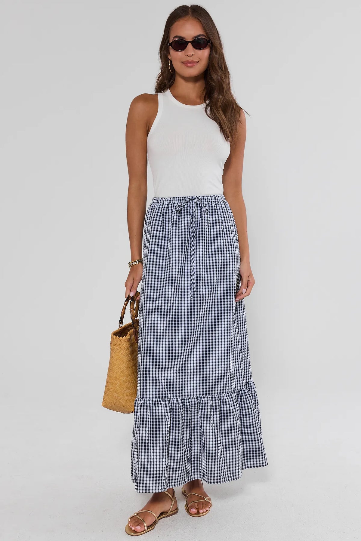 Blue gingham maxi skirt with white tank and woven bag, full-length on-model styled look | Avara